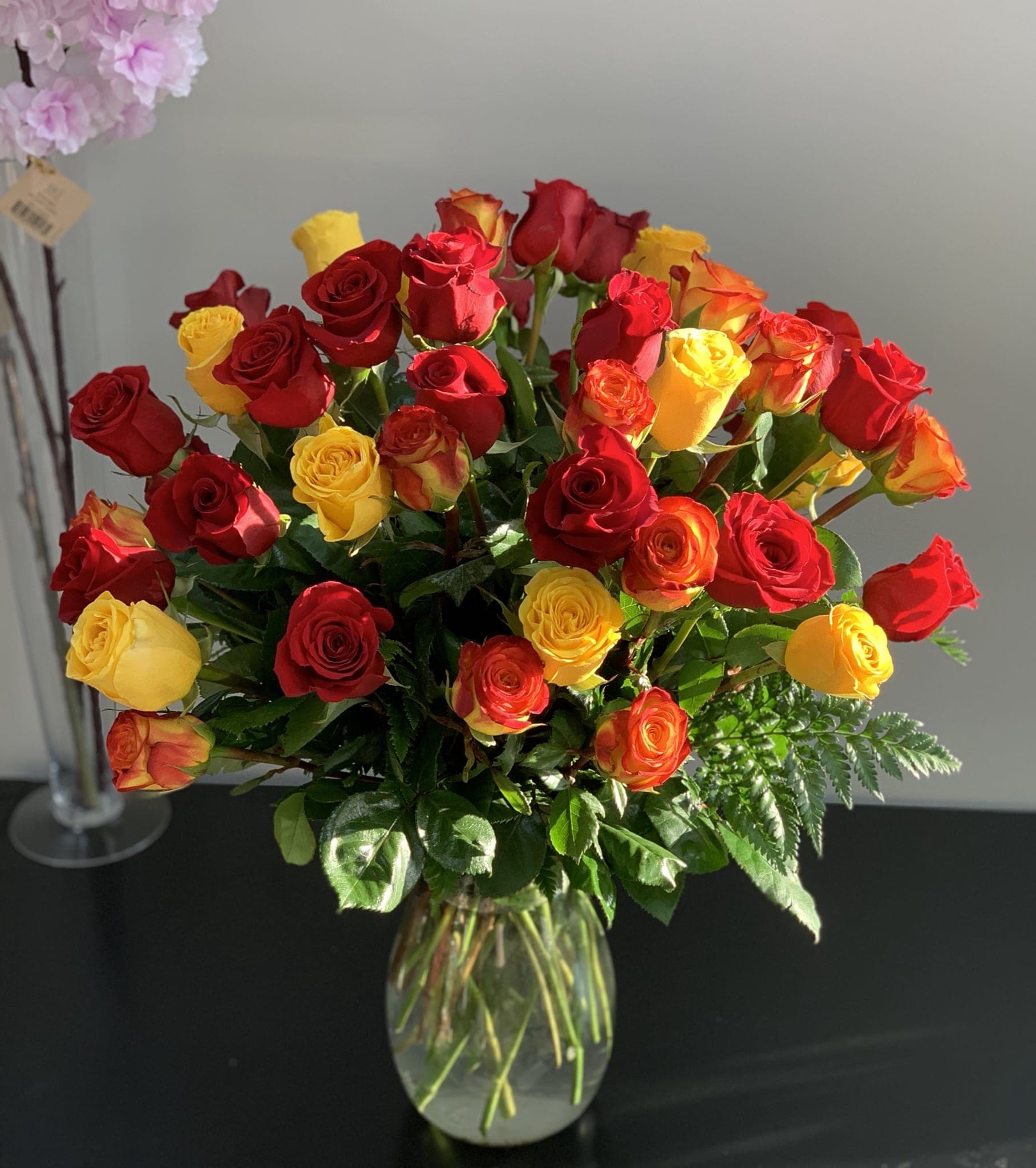 Bouquet of red and yellow roses in a clear glass vase
