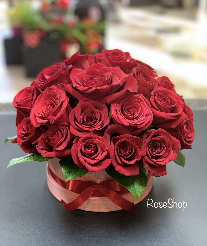 Bouquet of red roses in a round box with a ribbon