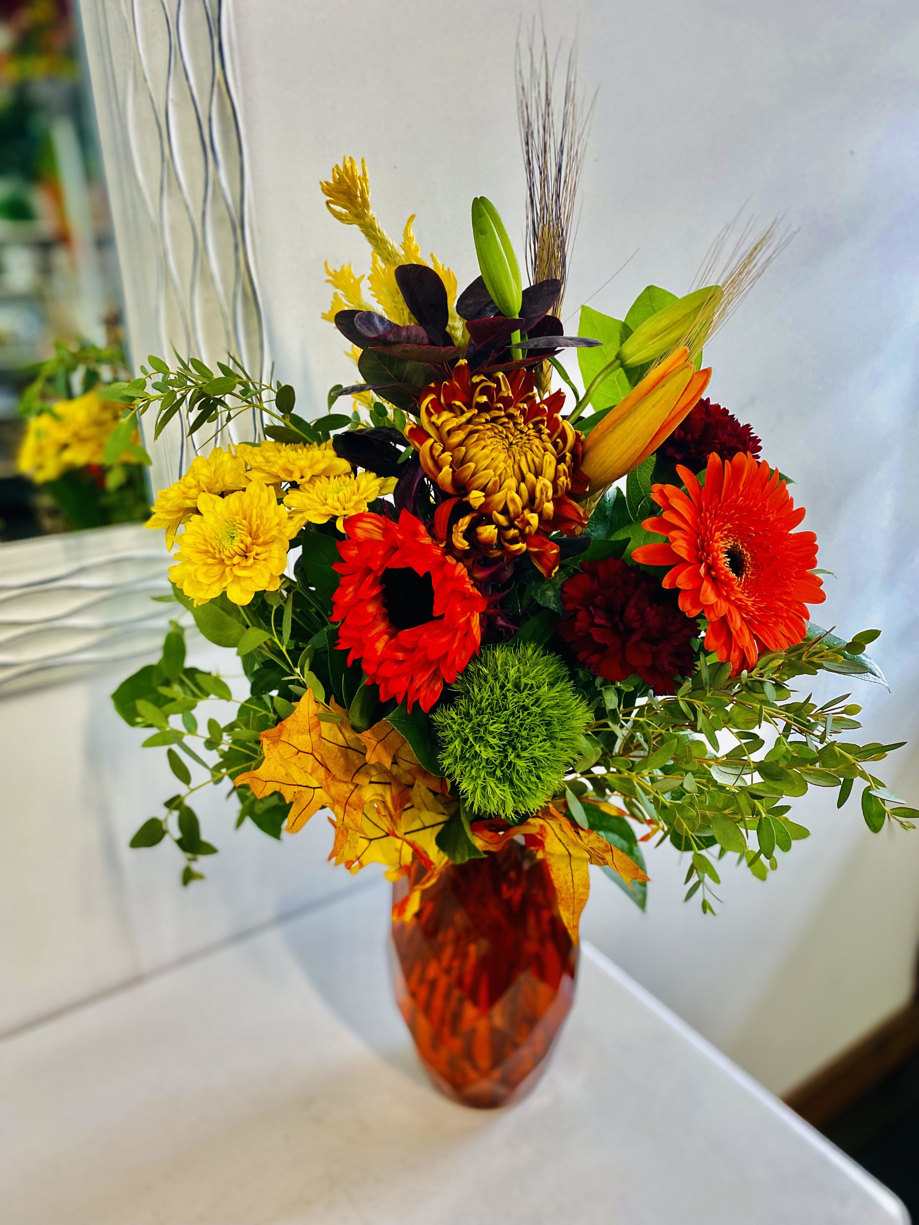 Fall Vase - Glass vase arrangement bursting with fall flowers and warm colors.