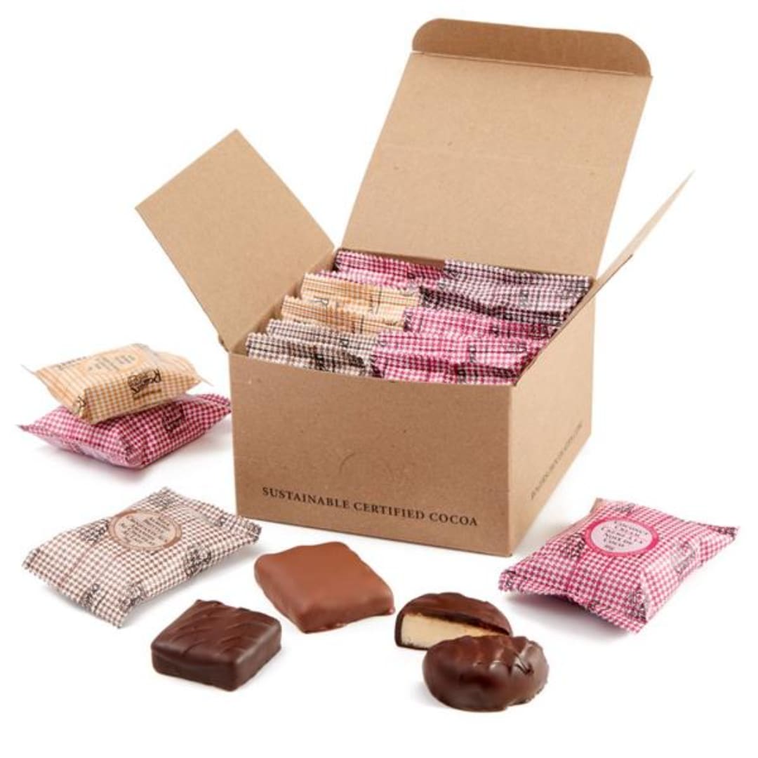 Box of assorted chocolates with several wrapped pieces and chocolates outside