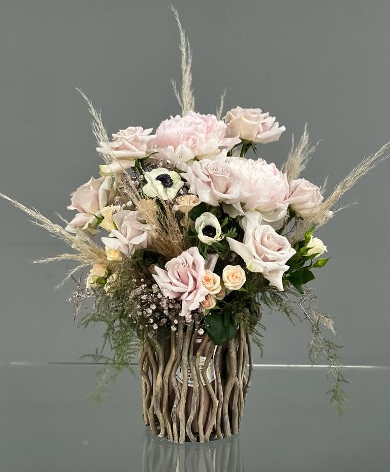 Blush rose arrangement in a tall decorative vase