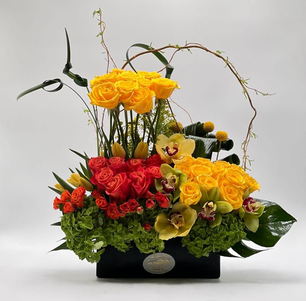 Yellow and red rose arrangement in a black box with orchids