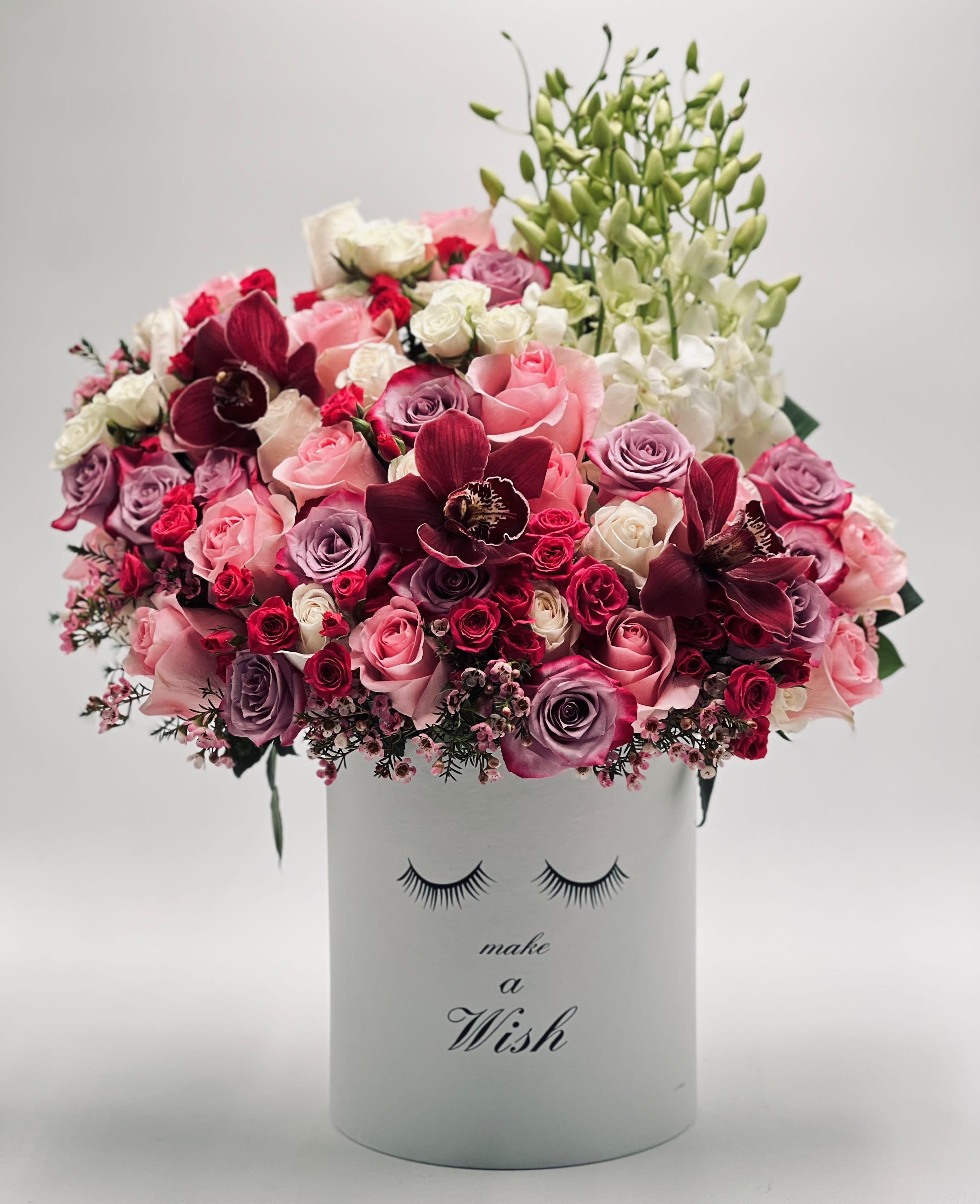 Pink and burgundy roses with orchids in a white box