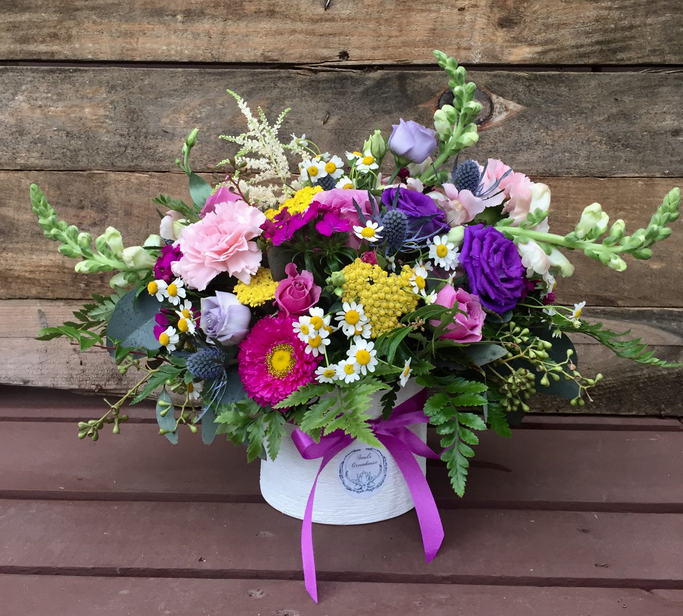 Mixed bouquet in a white hatbox with a purple ribbon