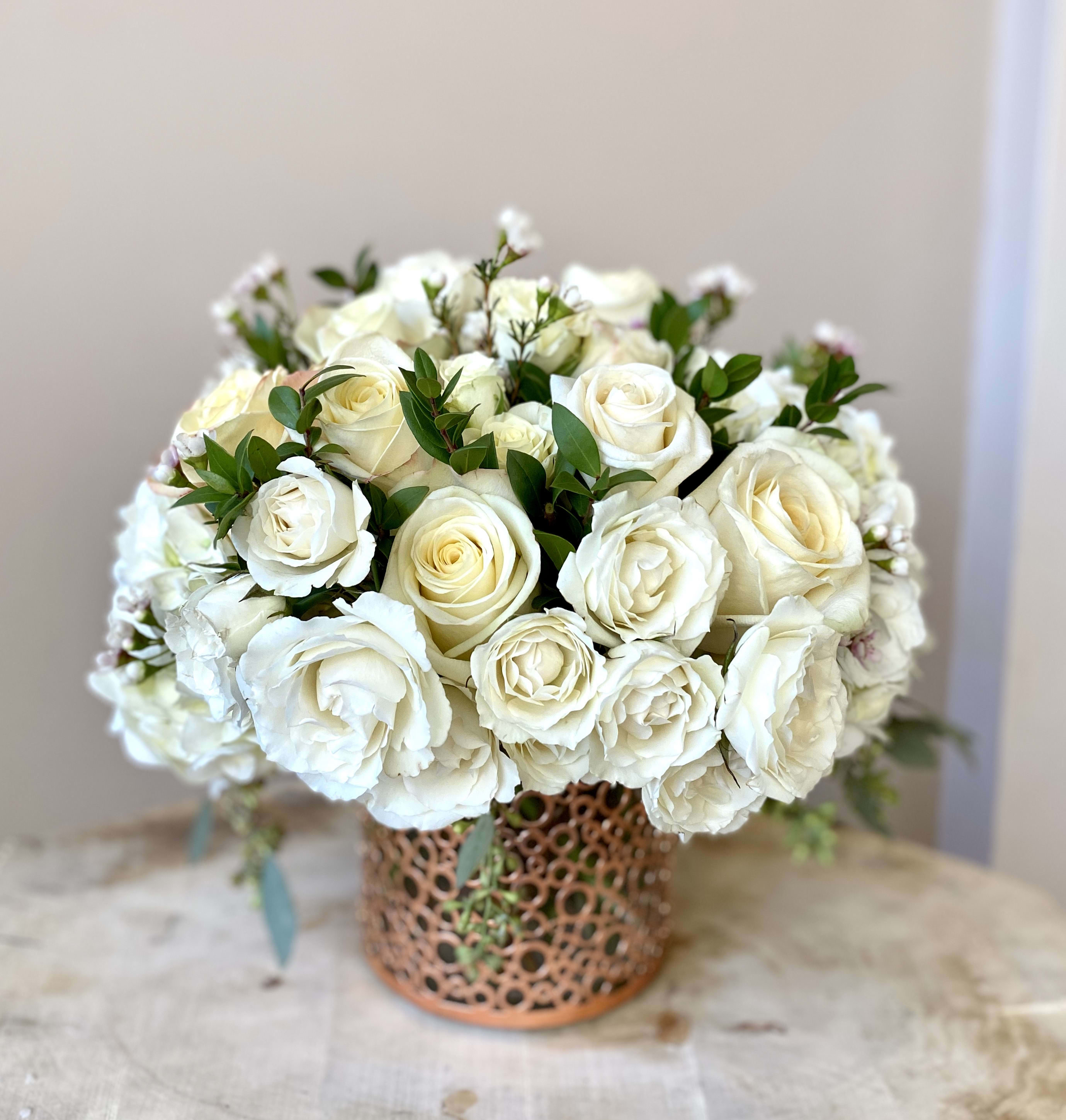 White rose bouquet in a decorative copper vase