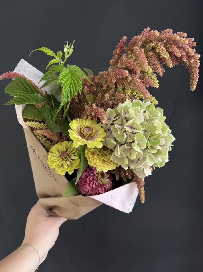 Handheld bouquet with yellow and pink flowers and pale green hydrangea