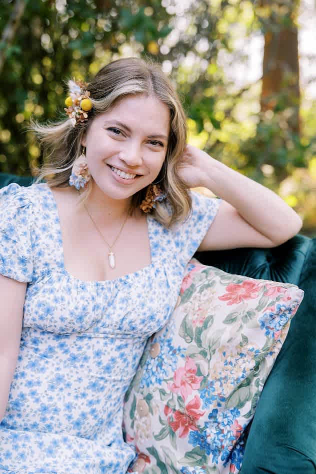 Woman wearing floral hair accessories and earrings outdoors