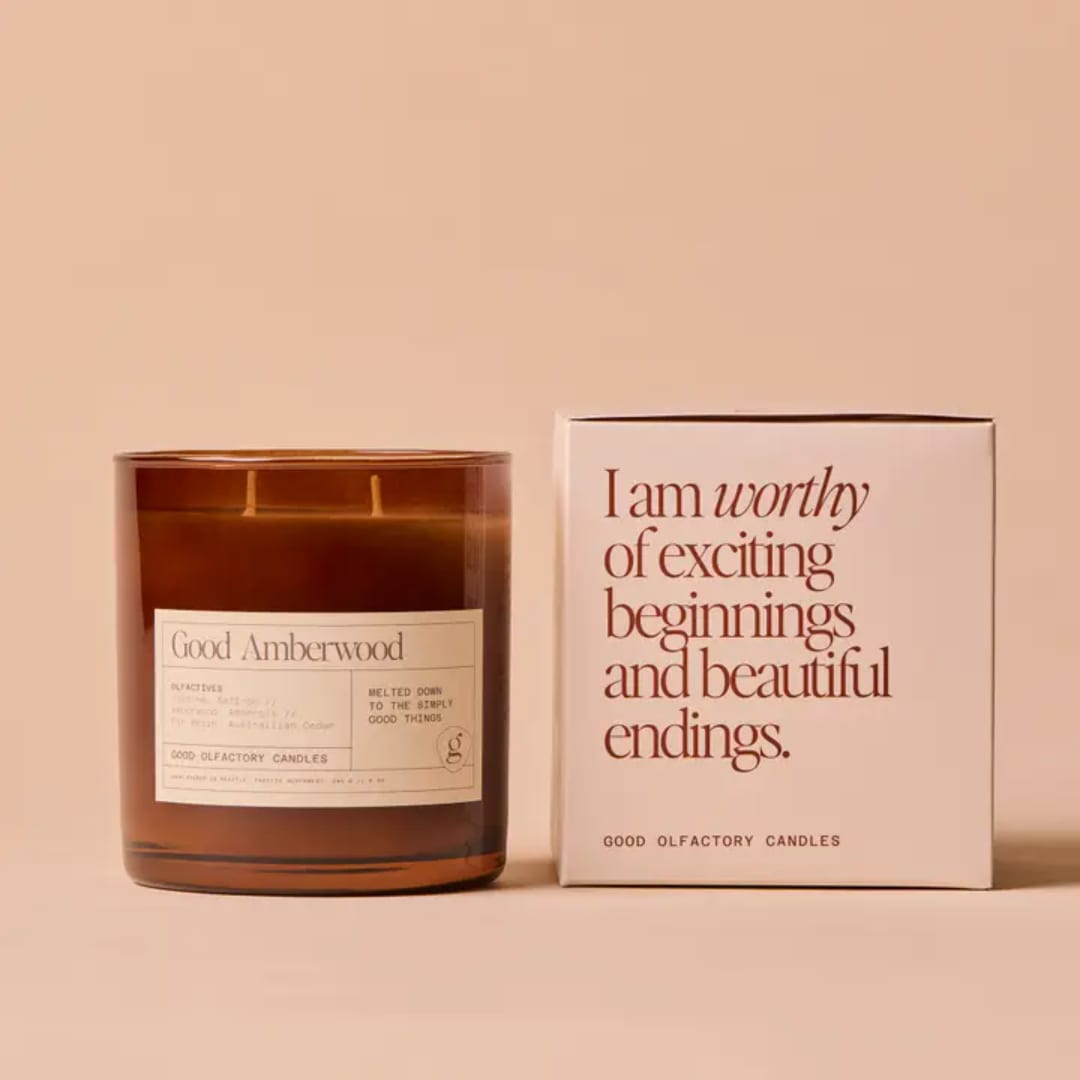 Amber glass candle beside a matching box with printed text