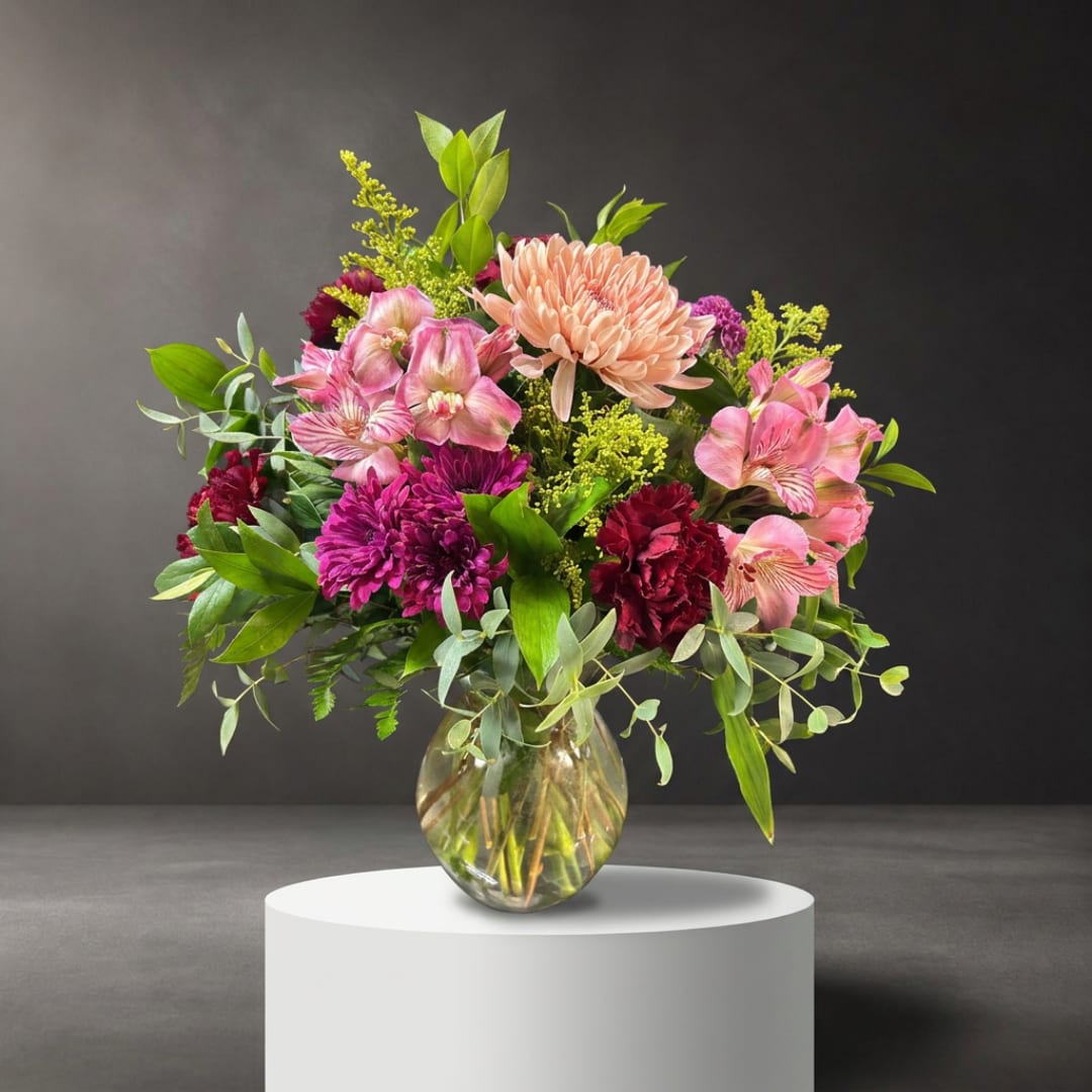 Mixed pink and purple flowers in a clear glass vase