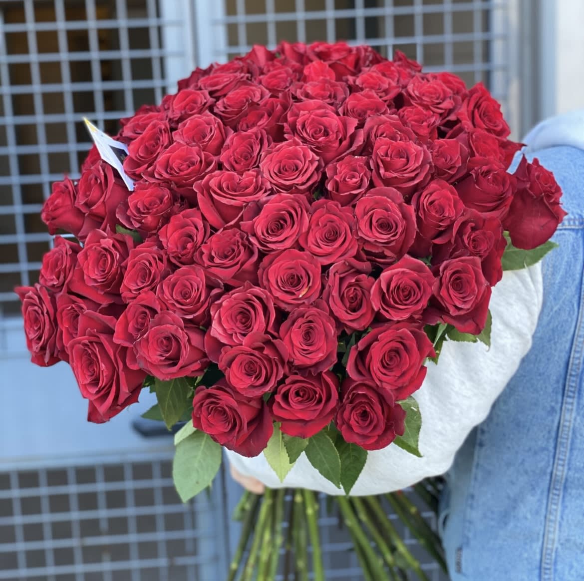 Large bouquet of red roses wrapped in white paper