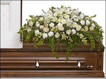 White floral spray on a wooden casket