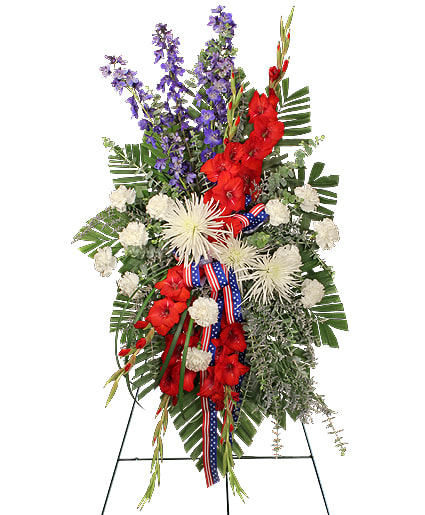 Patriotic standing spray of red, white, and blue flowers on an easel with flag ribbon