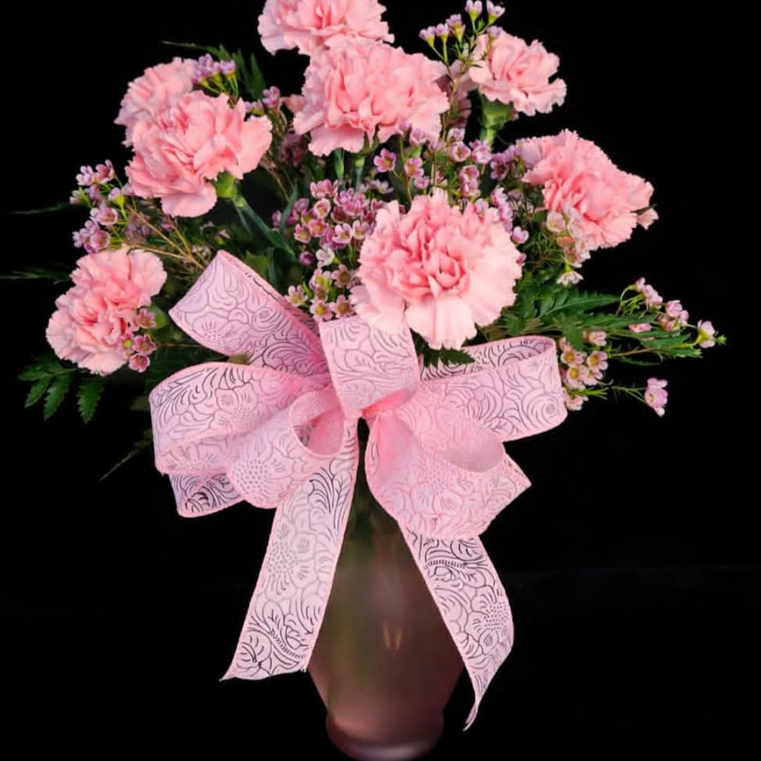 Pink carnations in a vase with a large pink bow