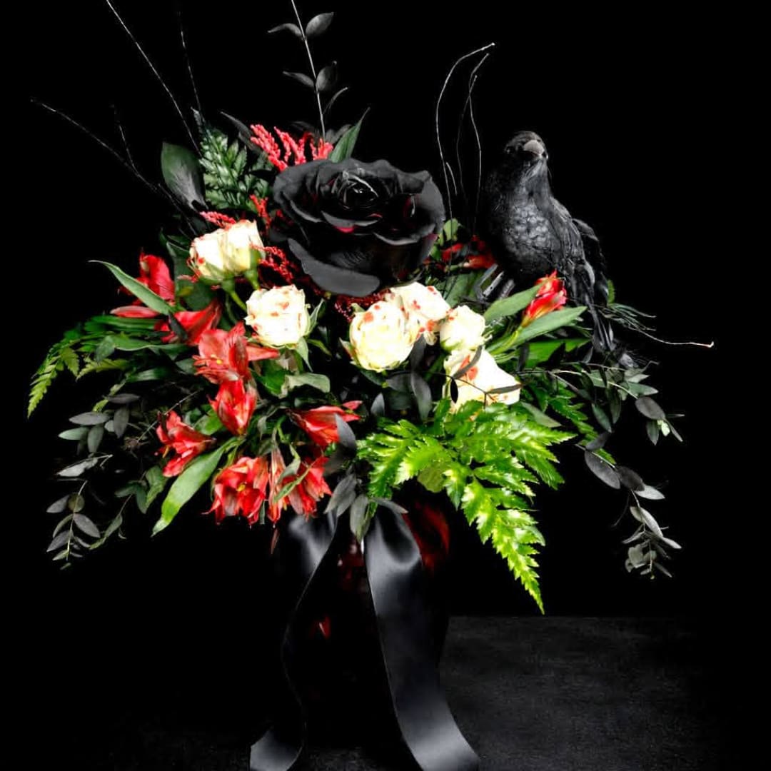 Black and red floral arrangement with a black bird figurine