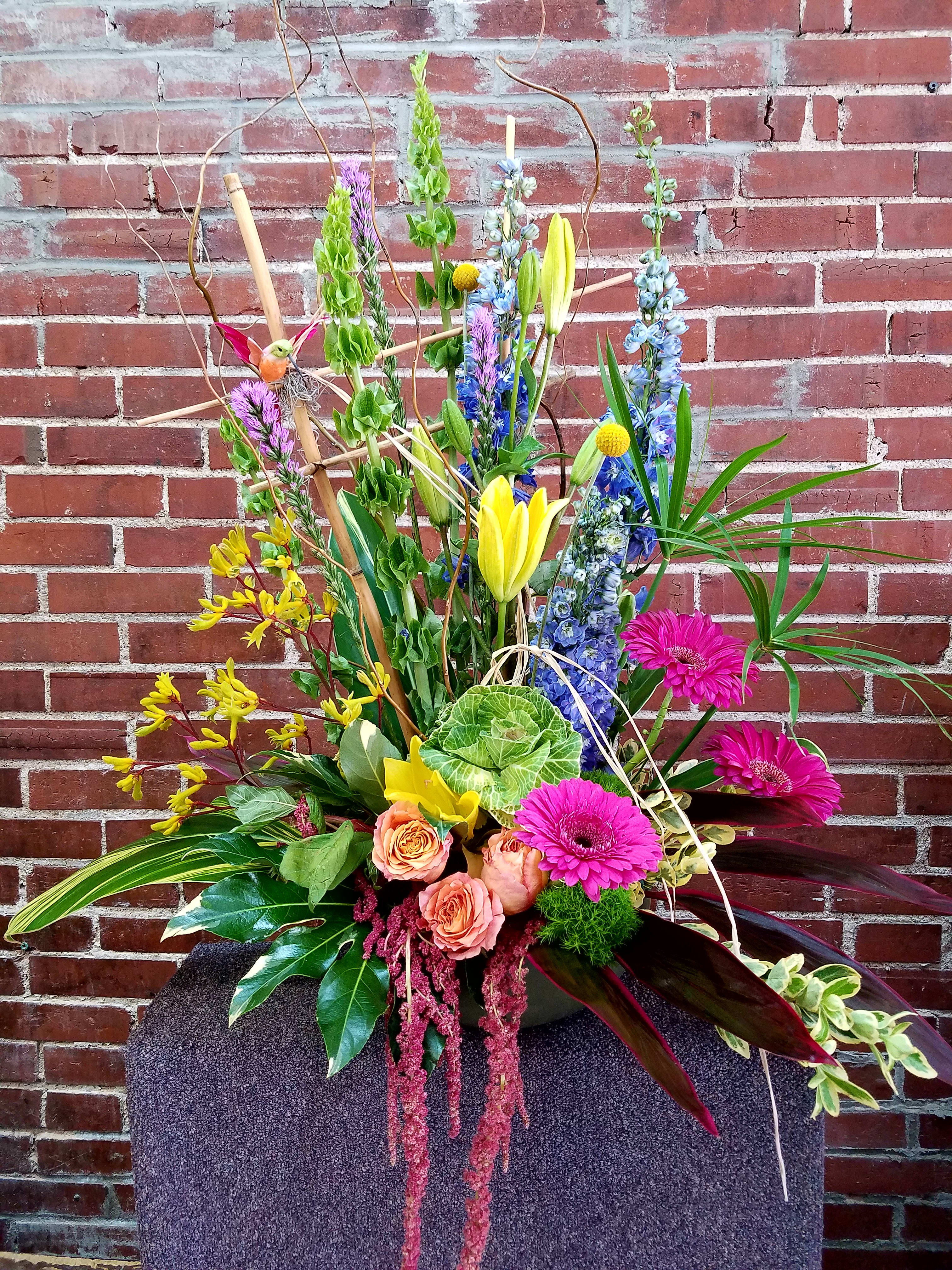 Tall mixed flower arrangement with pink gerberas, roses, and yellow lilies