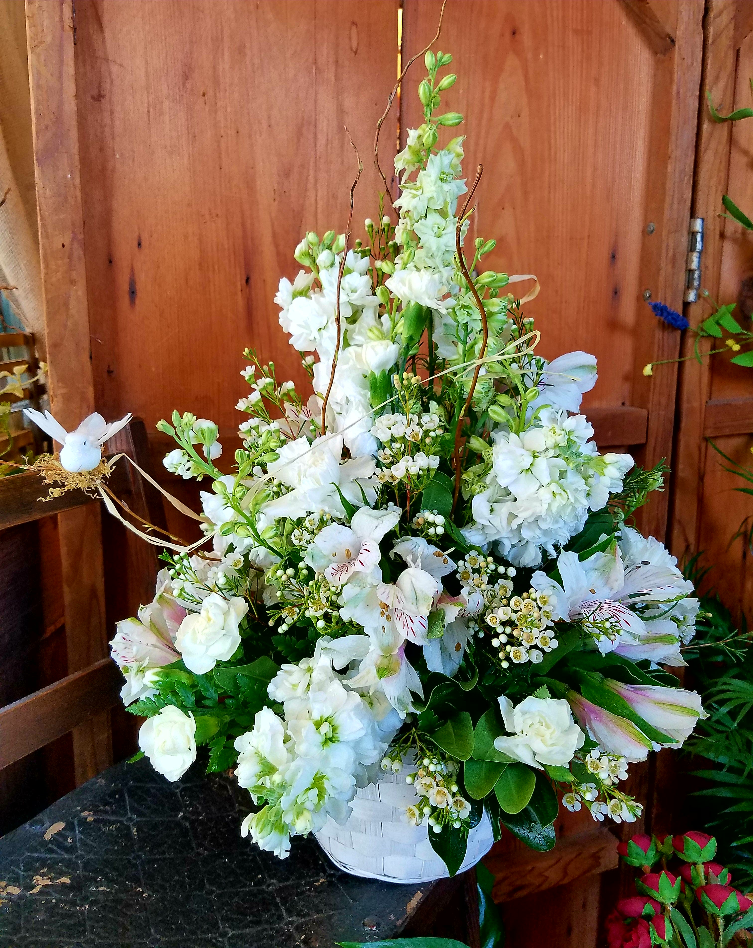 White mixed flower arrangement in a white basket