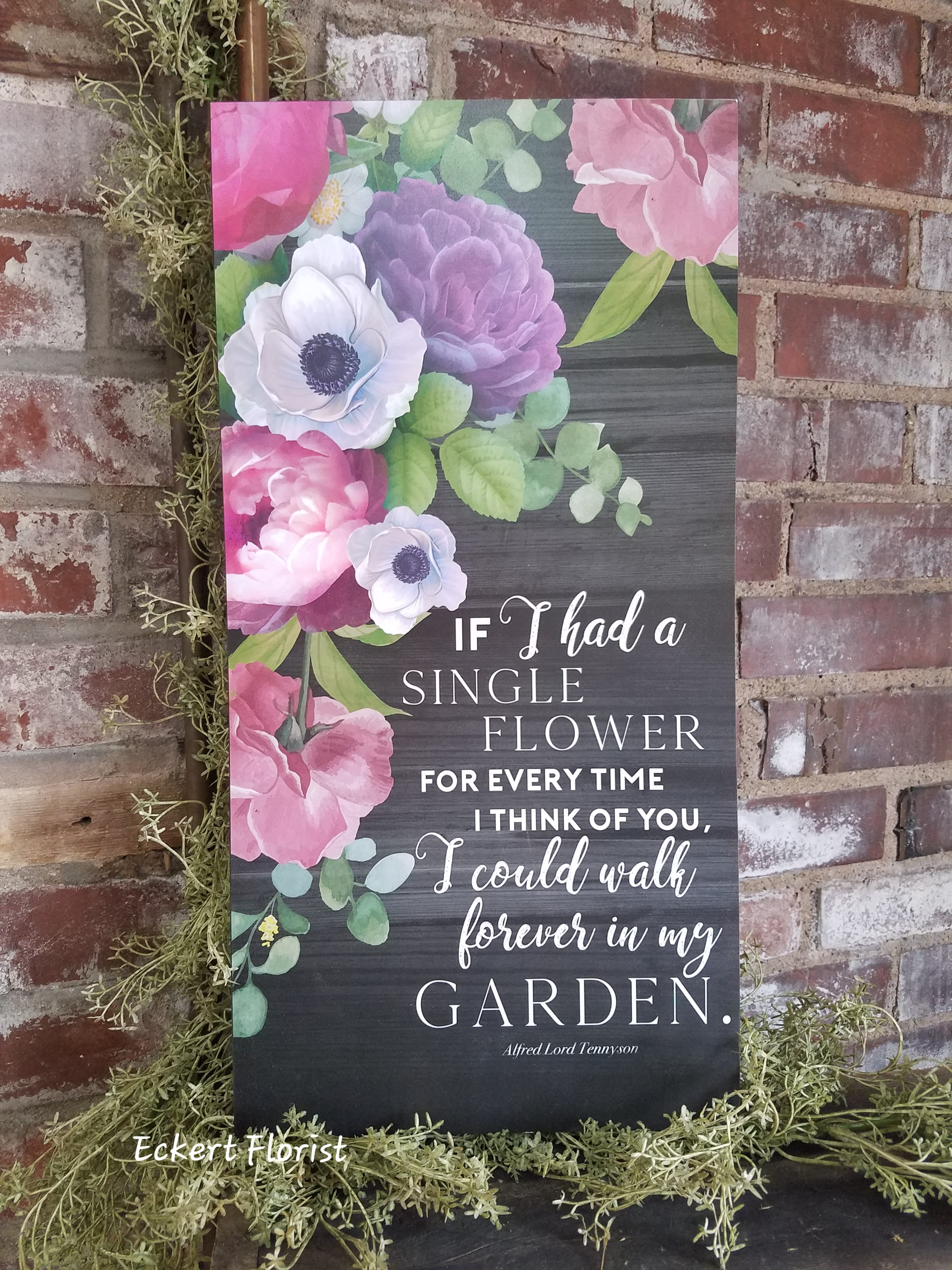 Floral wall sign with pink and purple blooms and a garden quote
