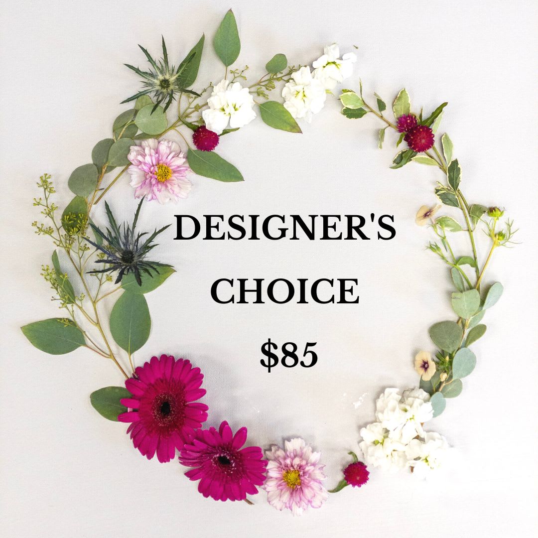Flat lay wreath of mixed pink, white, and green flowers encircling text reading Designer's Choice $85