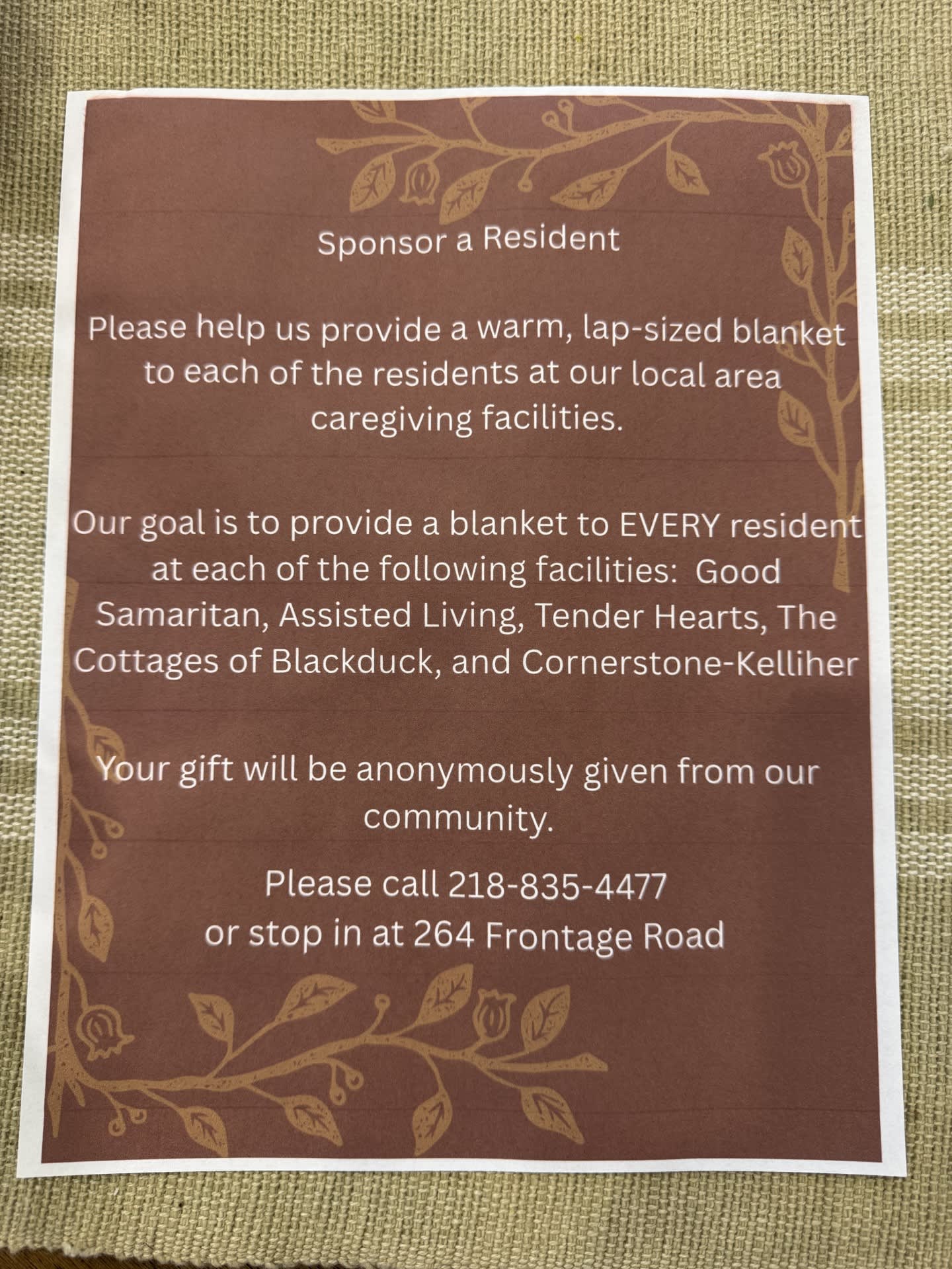 Printed donation flyer on a woven surface asking to sponsor a resident.
