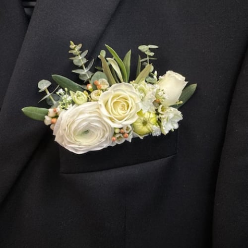 White floral boutonniere on a black suit jacket