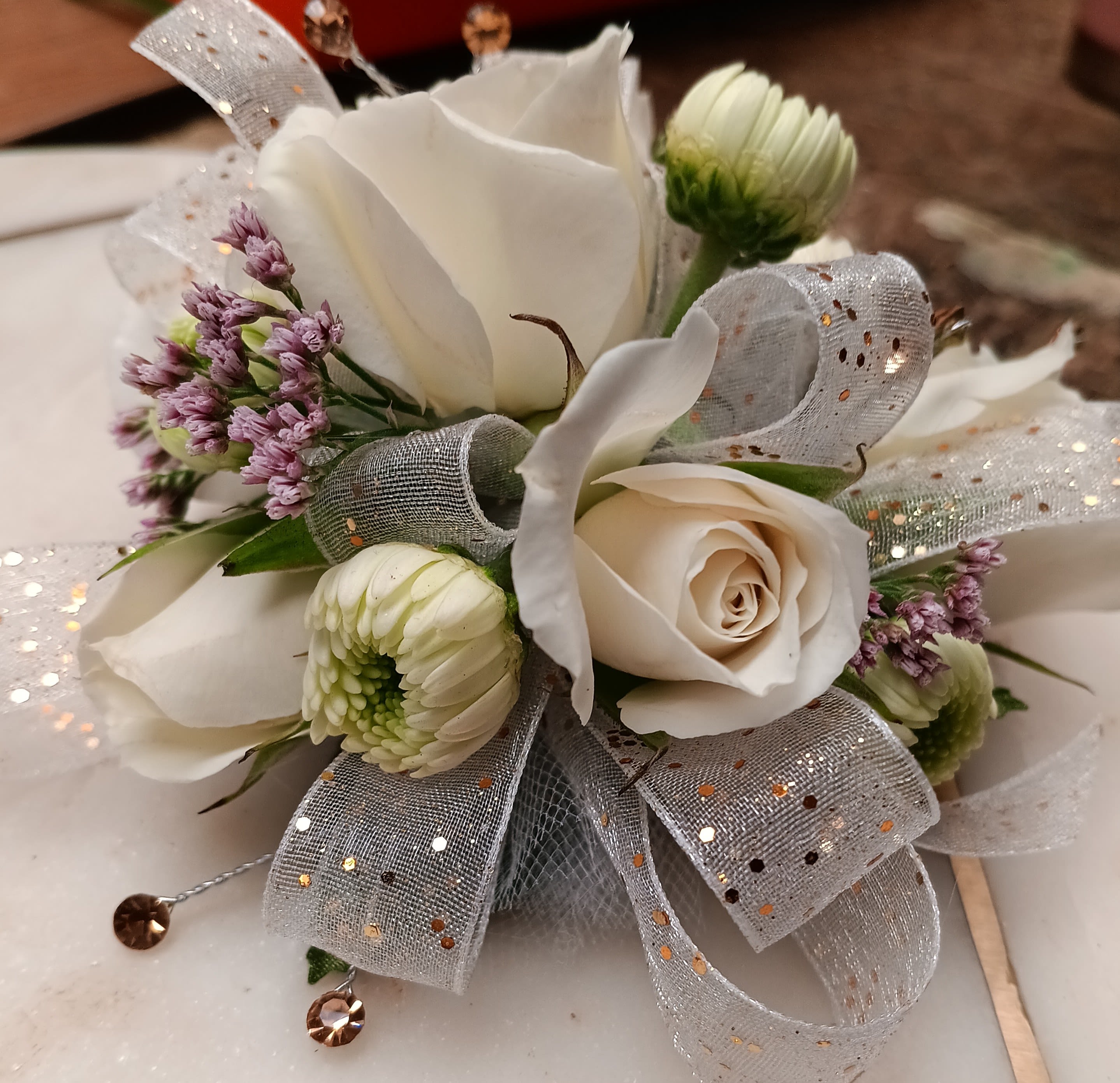 White rose corsage with small white blooms and silver ribbon