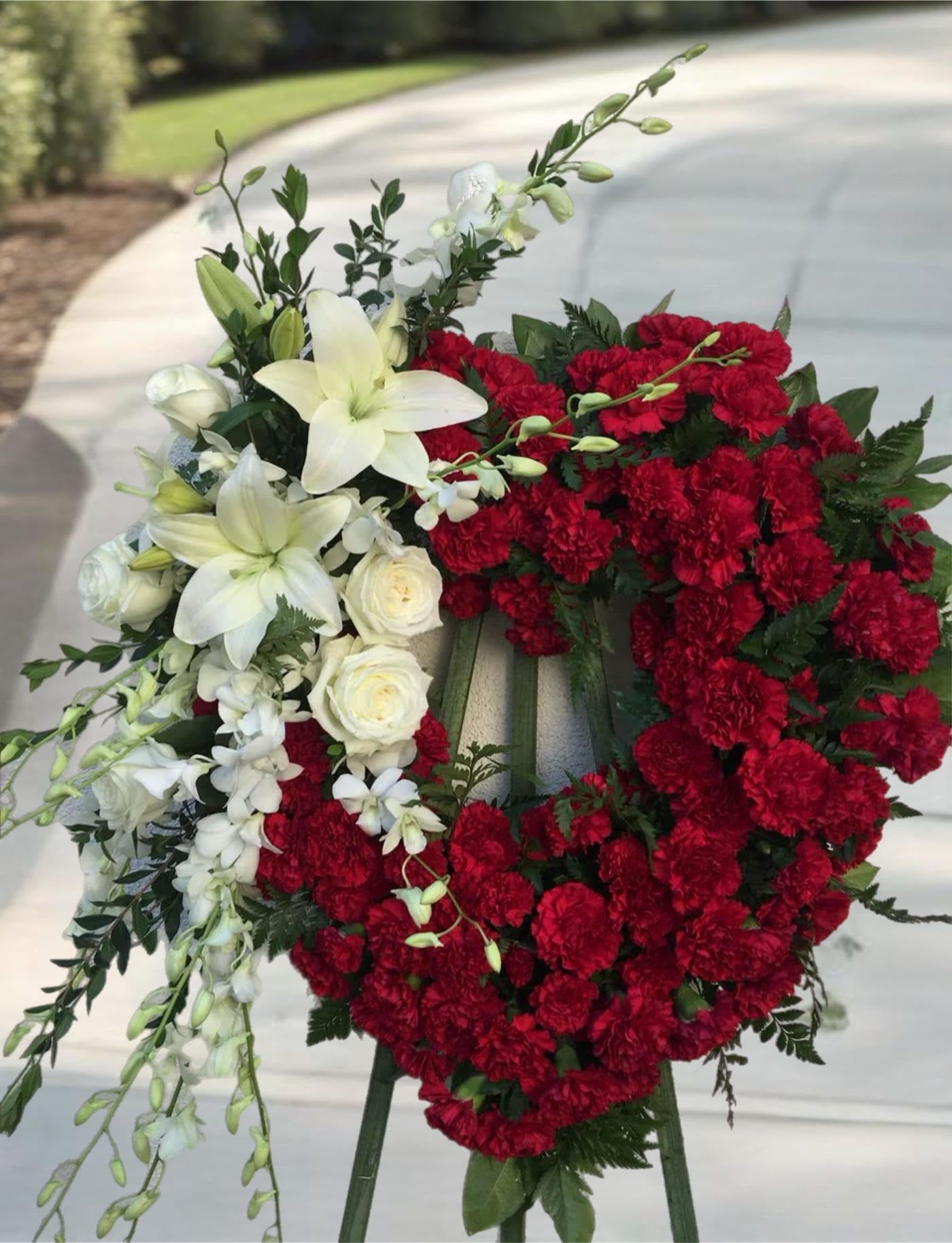 Red and white floral funeral wreath on an easel