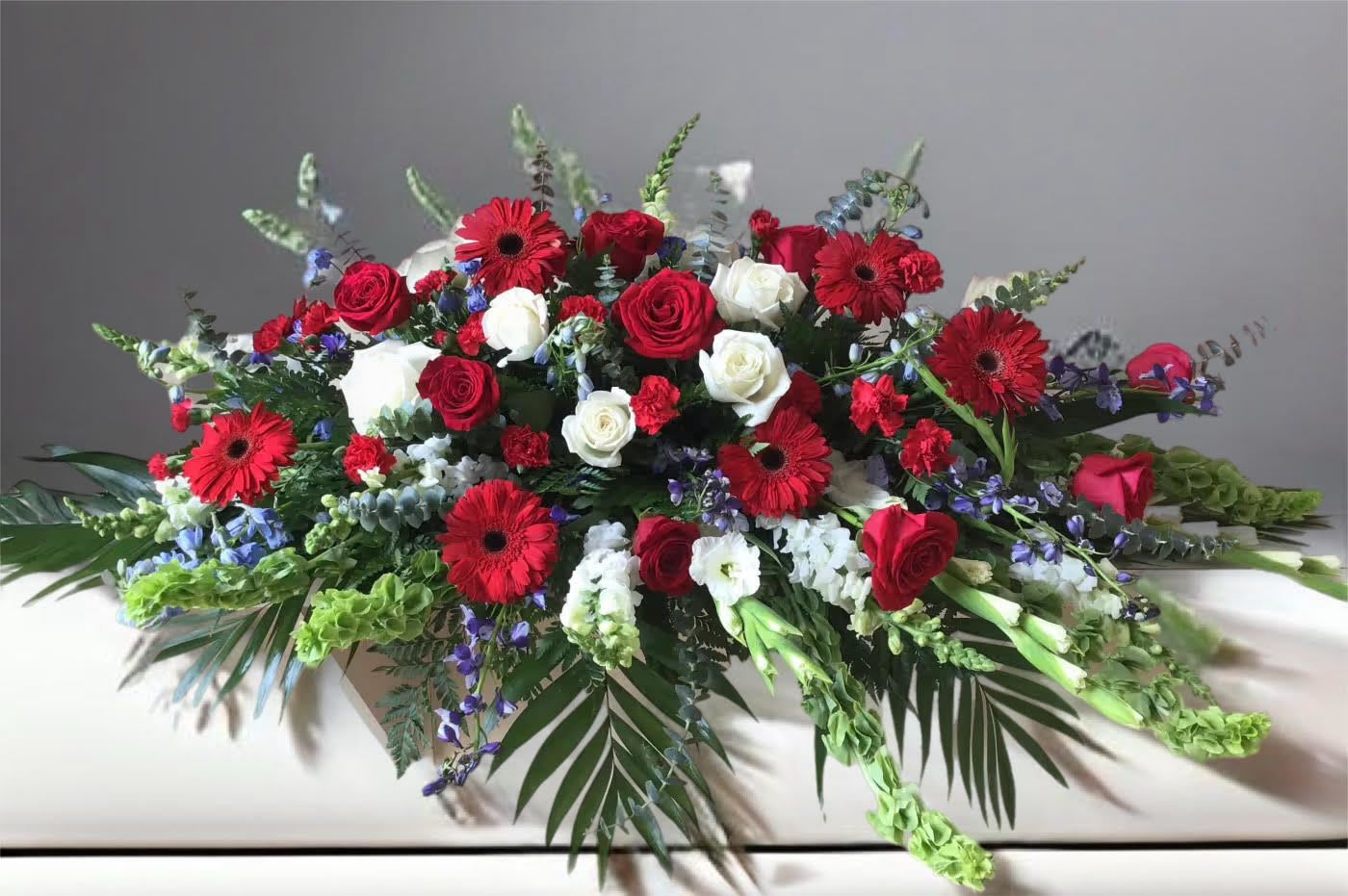 Large arrangement of red and white roses with red gerbera daisies