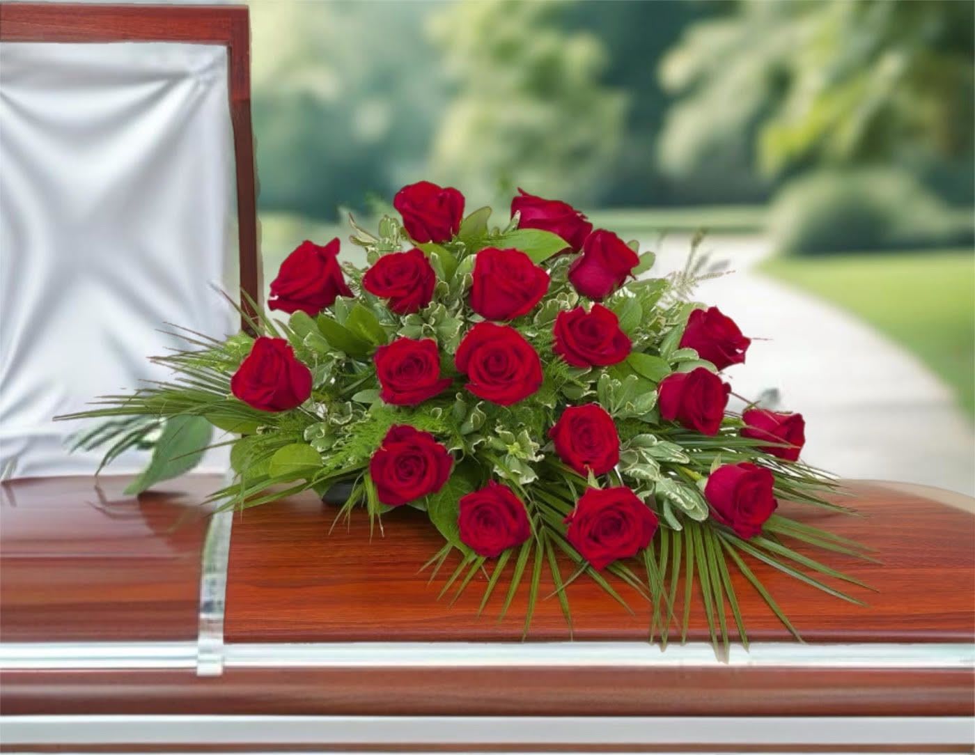 Red rose casket spray on a polished wooden coffin