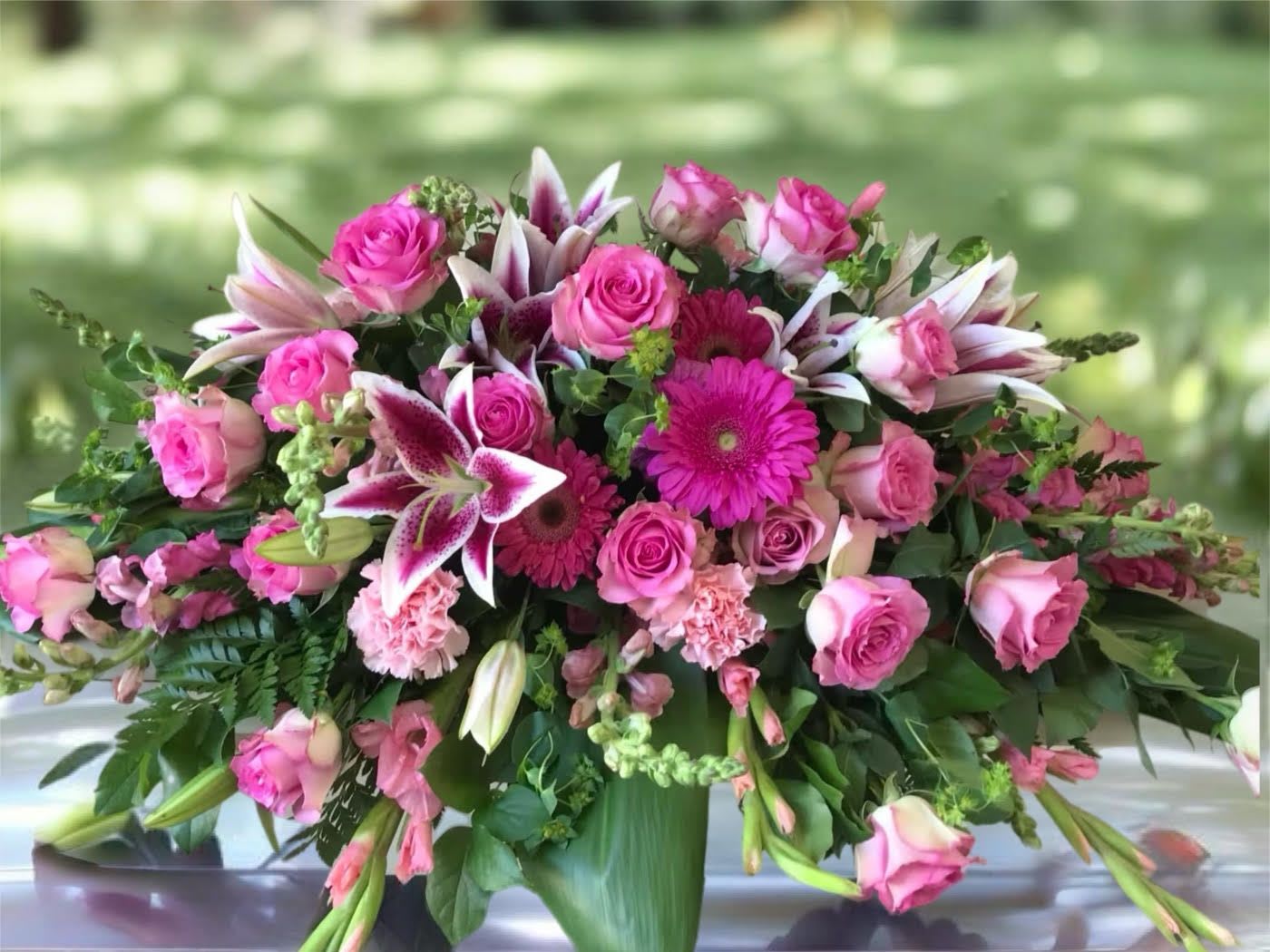 Pink roses and lilies arranged in a low vase centerpiece