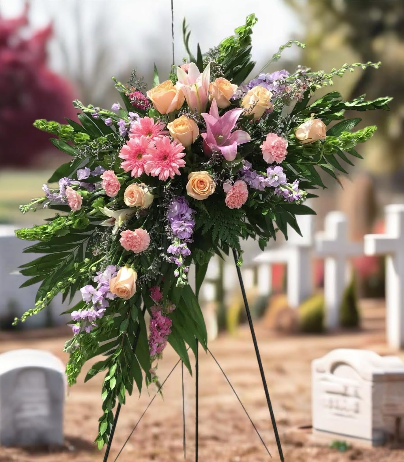 Standing floral spray with pink roses, lilies, and lavender blooms