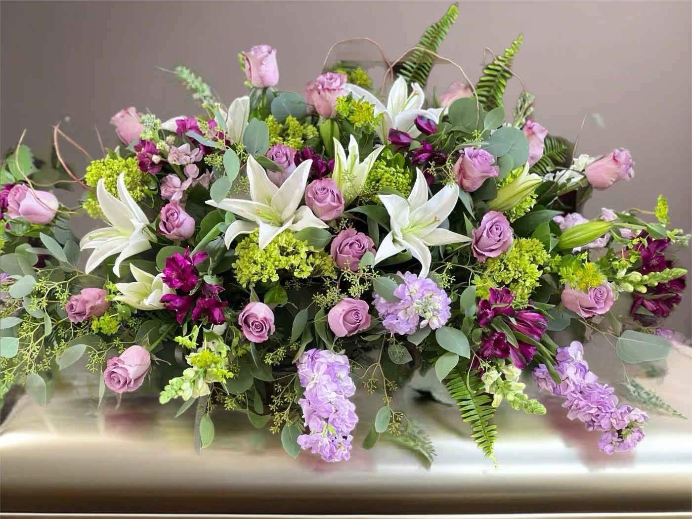 Lavender roses and white lilies in a low floral arrangement