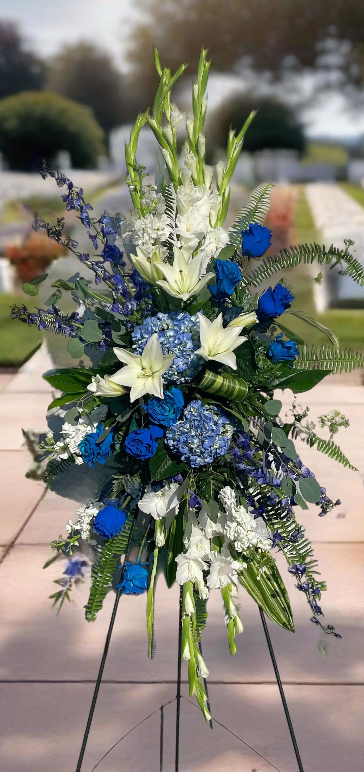 Tall blue and white floral standing spray on an easel