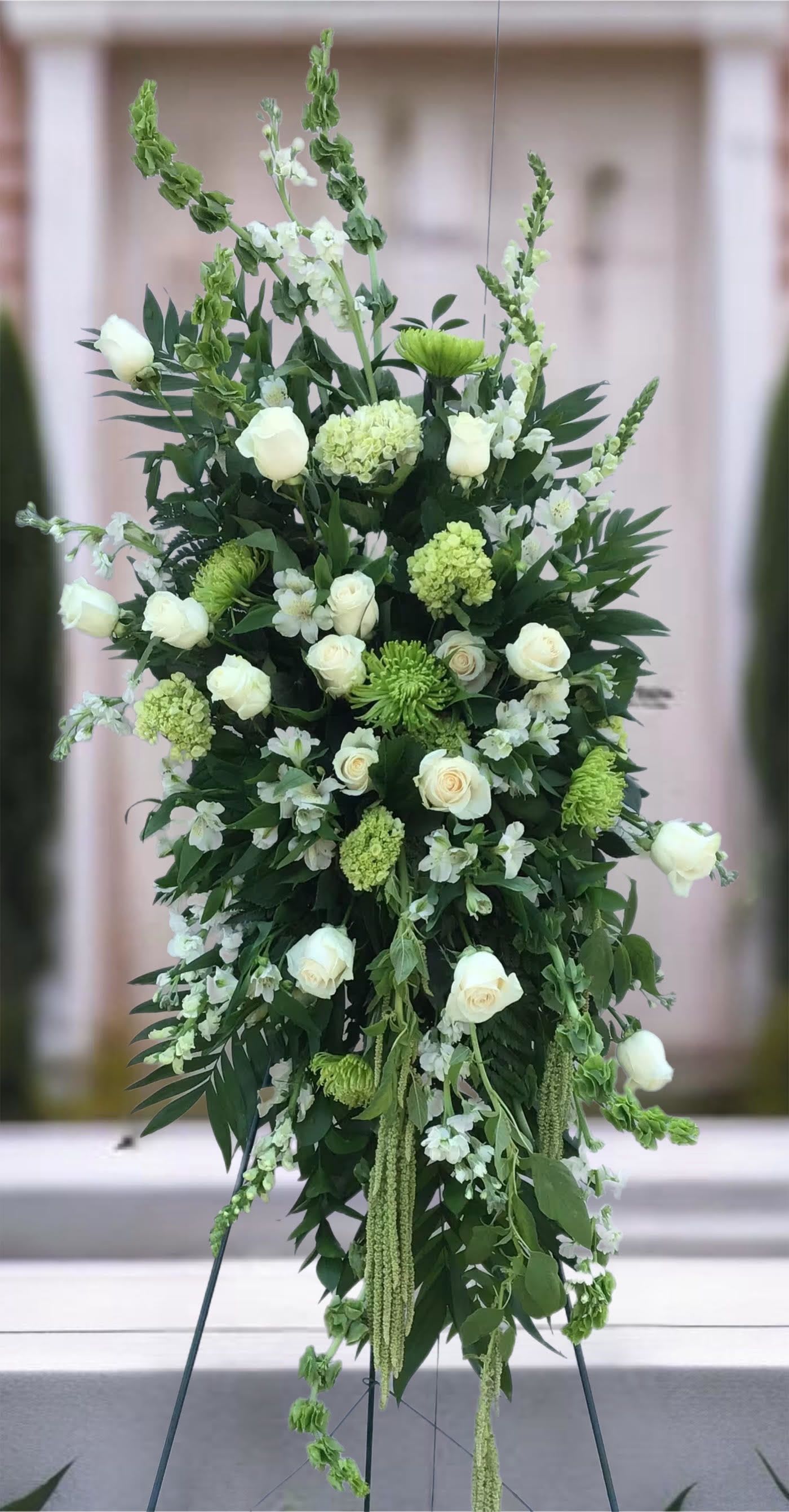 Tall white and green floral standing spray on an easel