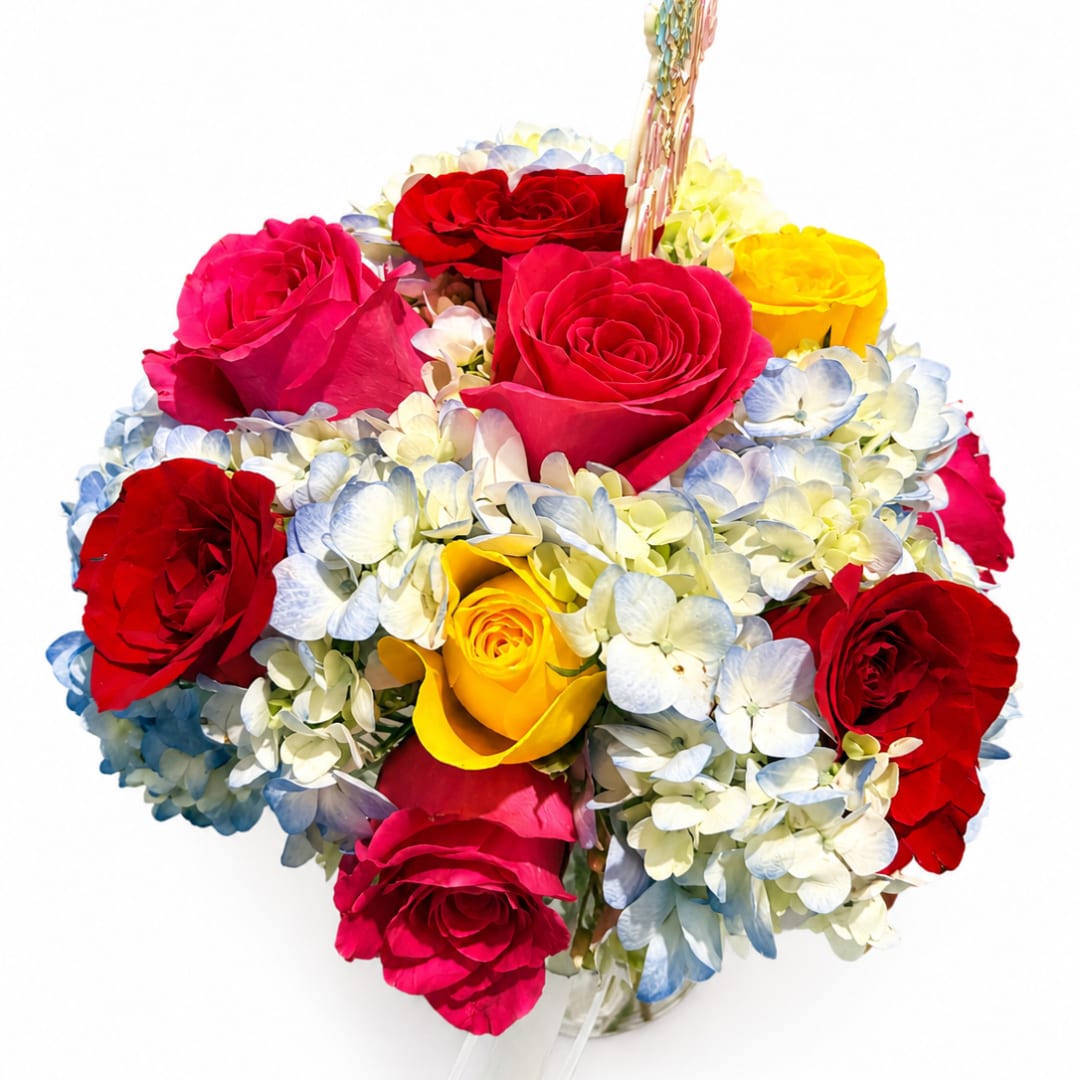 Bouquet of red, pink, and yellow roses with pale blue hydrangeas