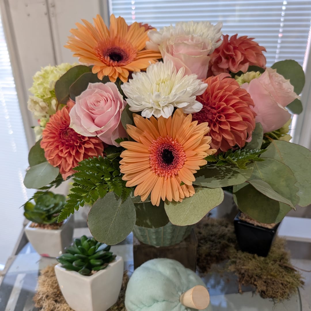 Bouquet of pink roses, orange gerberas, and white mums in a vase
