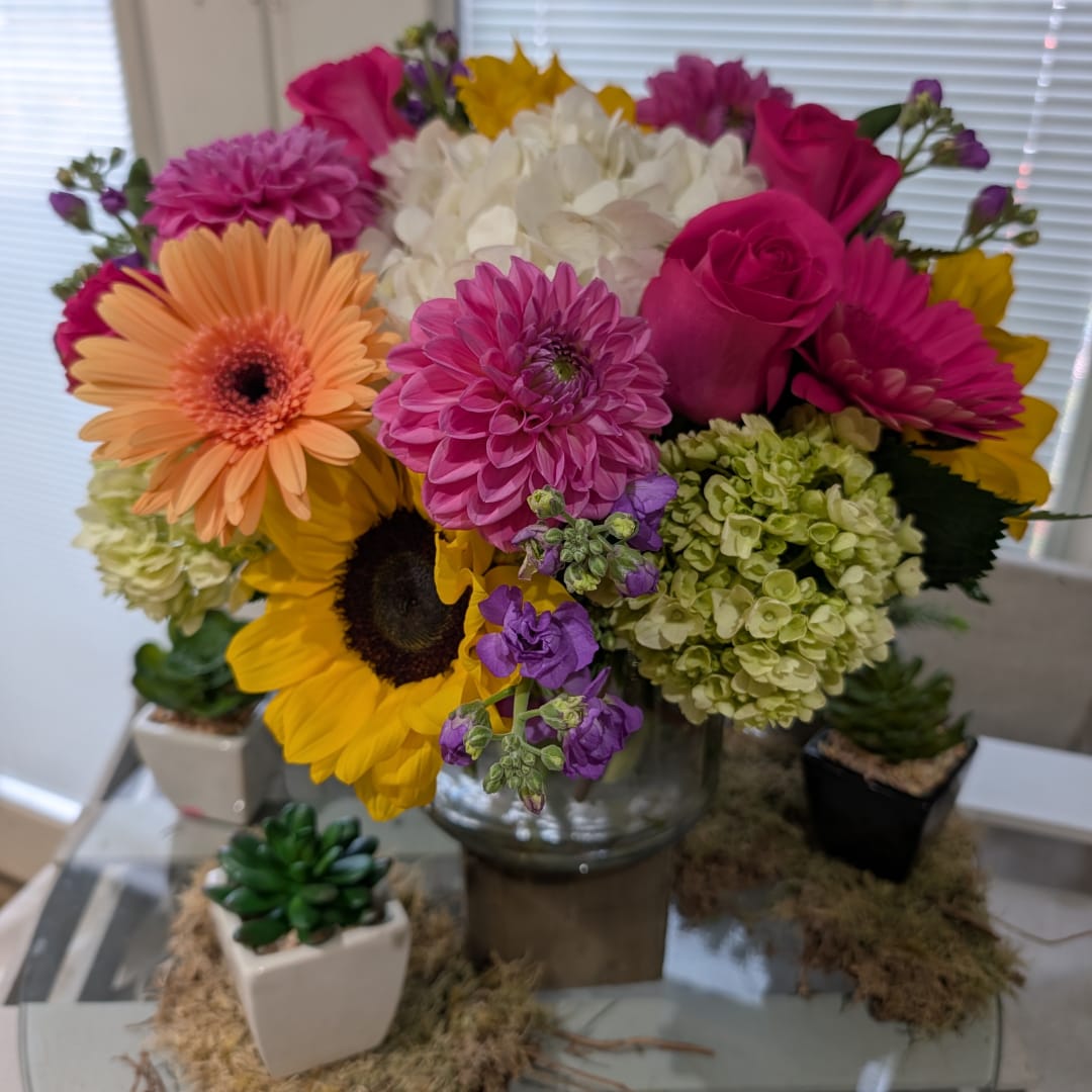 Mixed bouquet of bright flowers in a glass vase