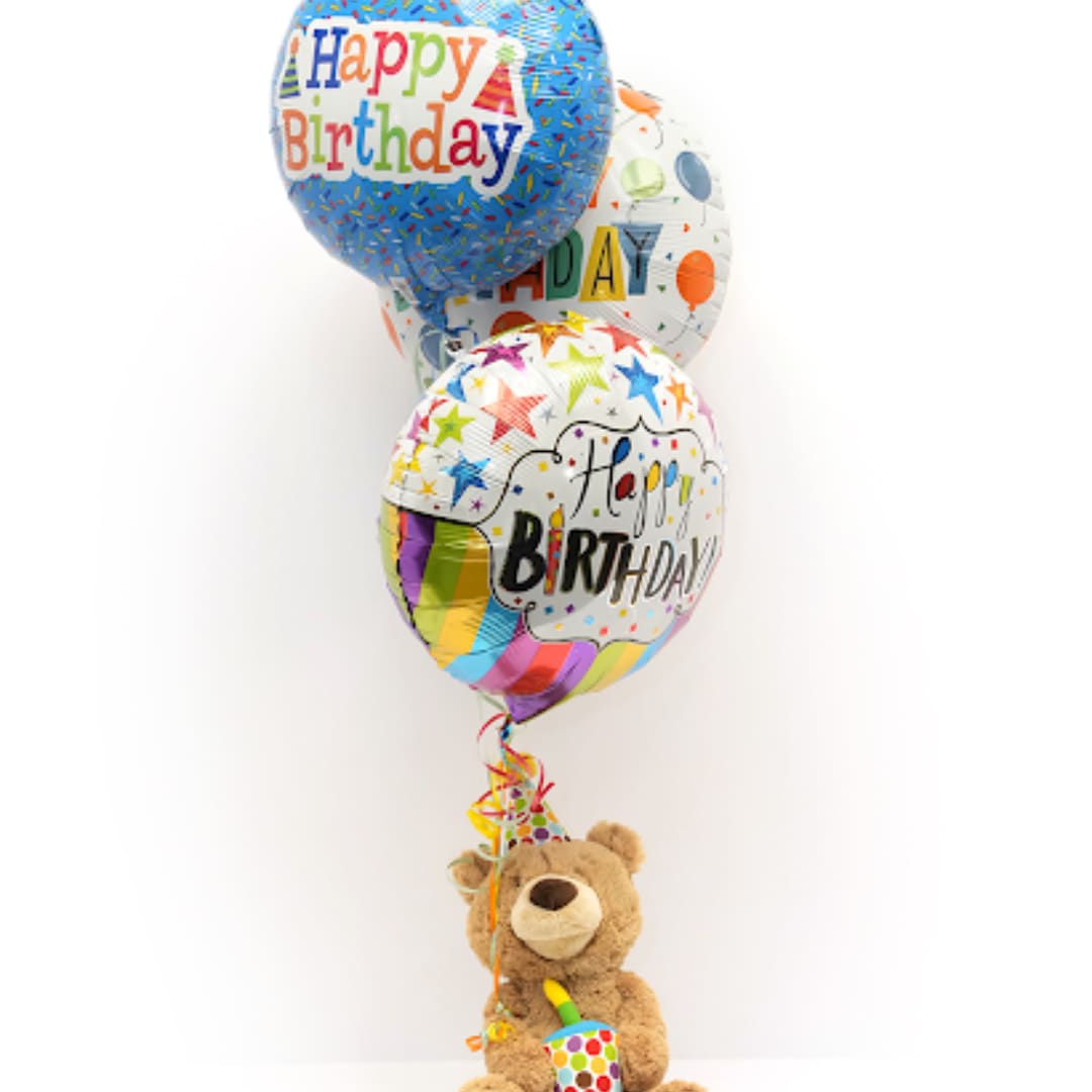Birthday balloons with a teddy bear holding a party horn