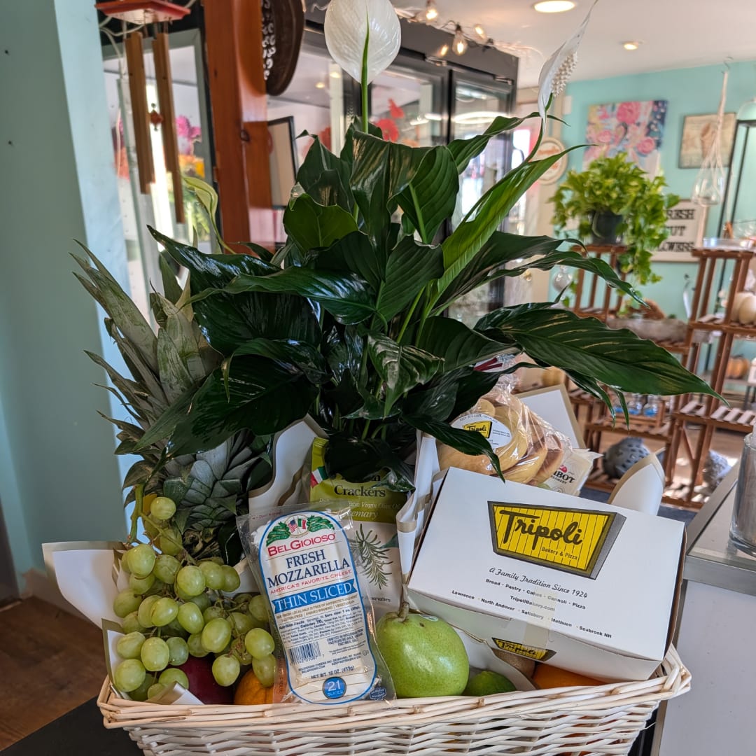 Gift basket with a potted peace lily, fruit, cheese, and crackers
