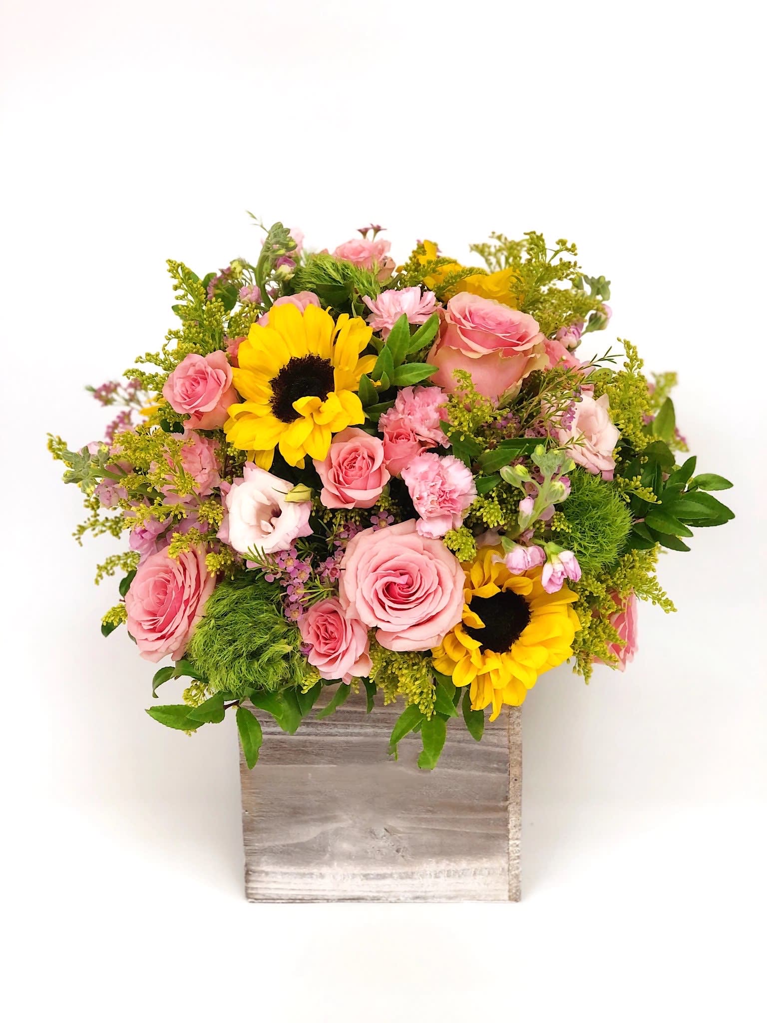 Pink roses and sunflowers in a wooden box