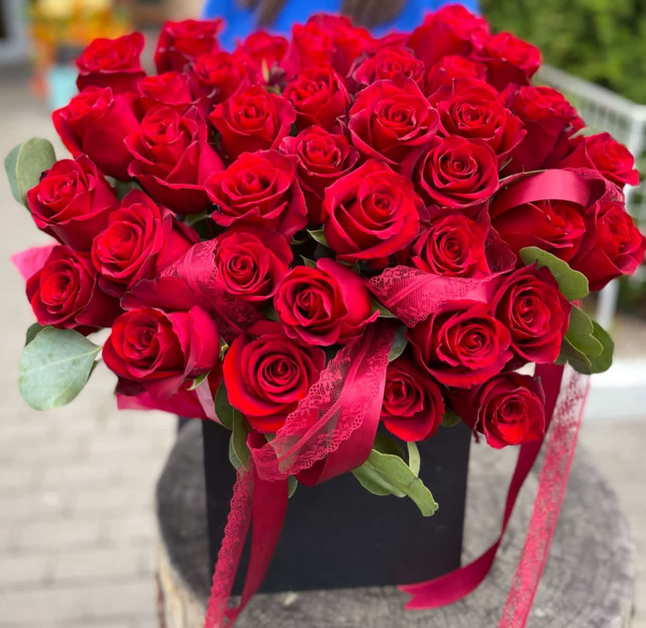 Bouquet of red roses with pink ribbon in a black box
