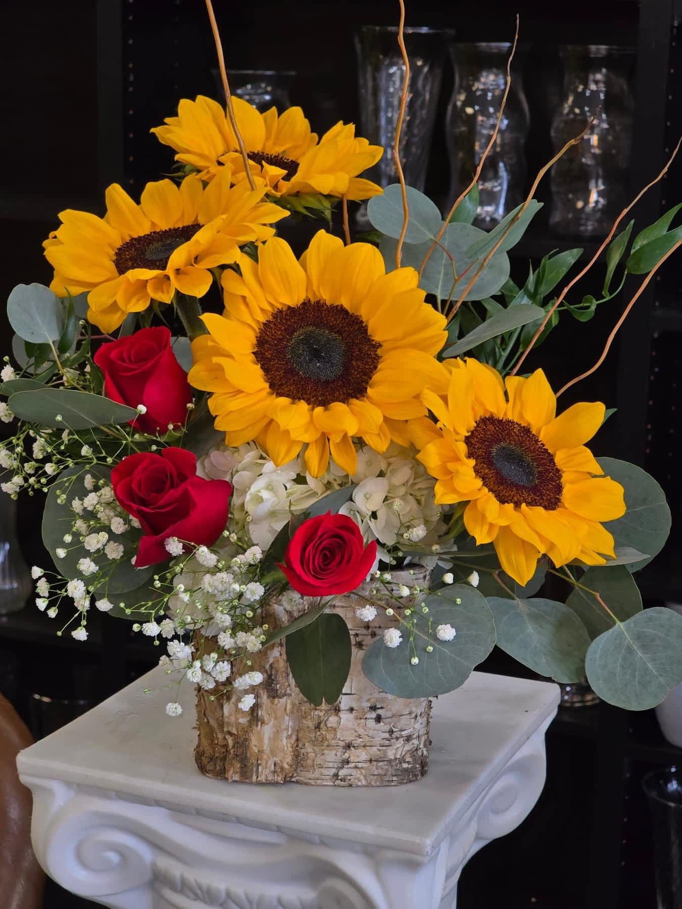 Sunflower and red rose arrangement in a birch-style container