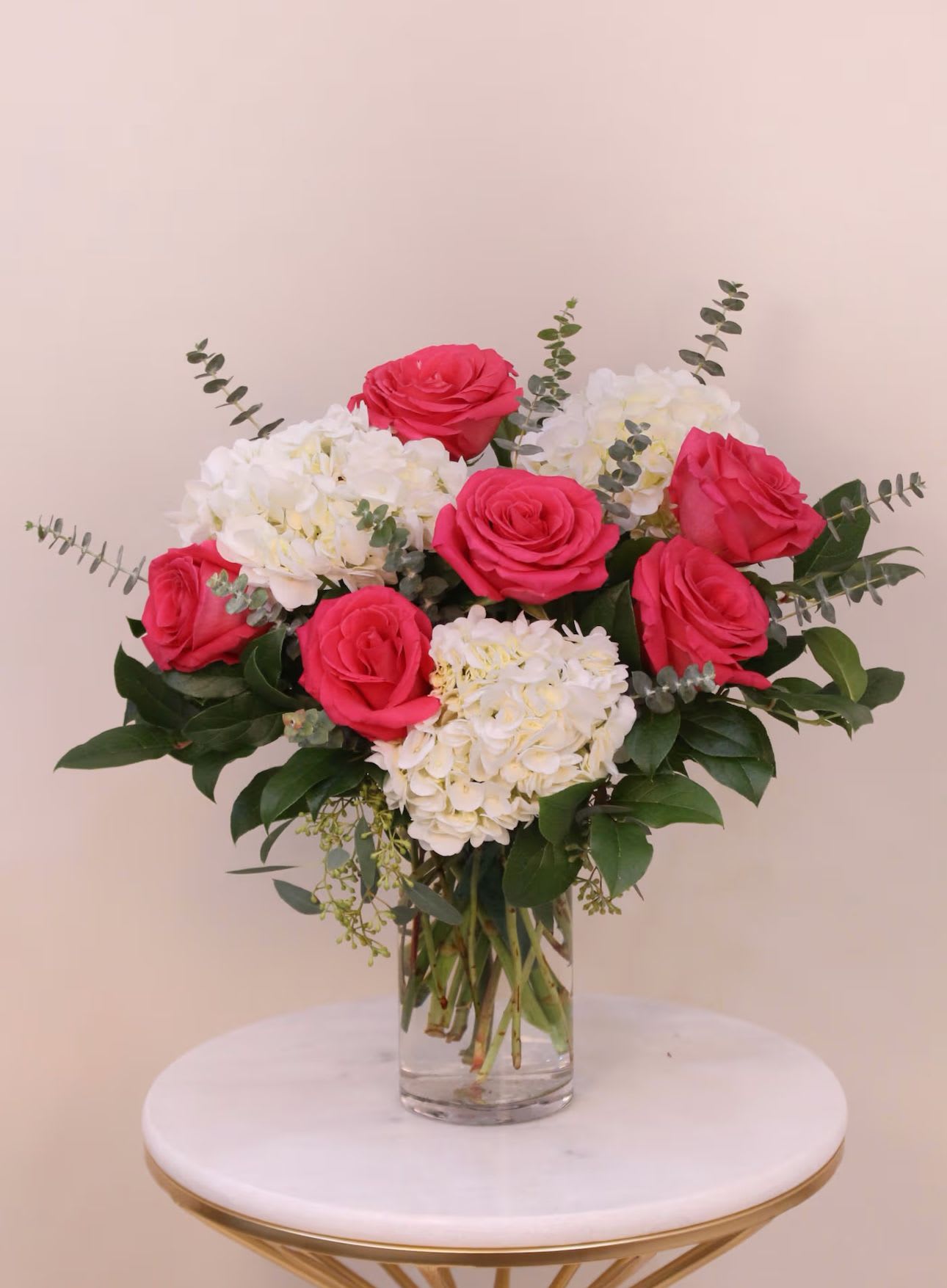 Pink roses and white hydrangeas in a clear glass vase