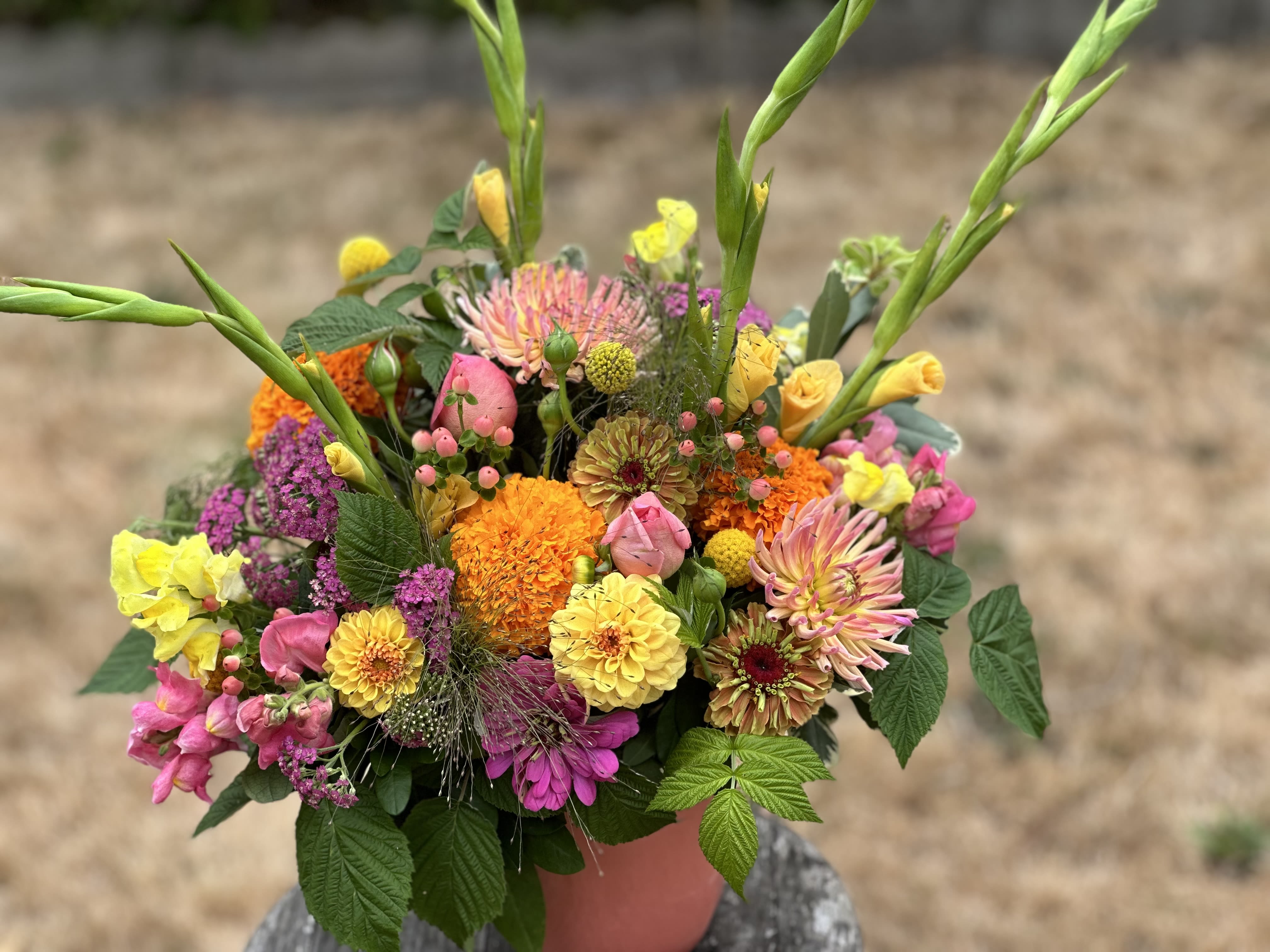 Colorful mixed bouquet in a pink container with tall green stems