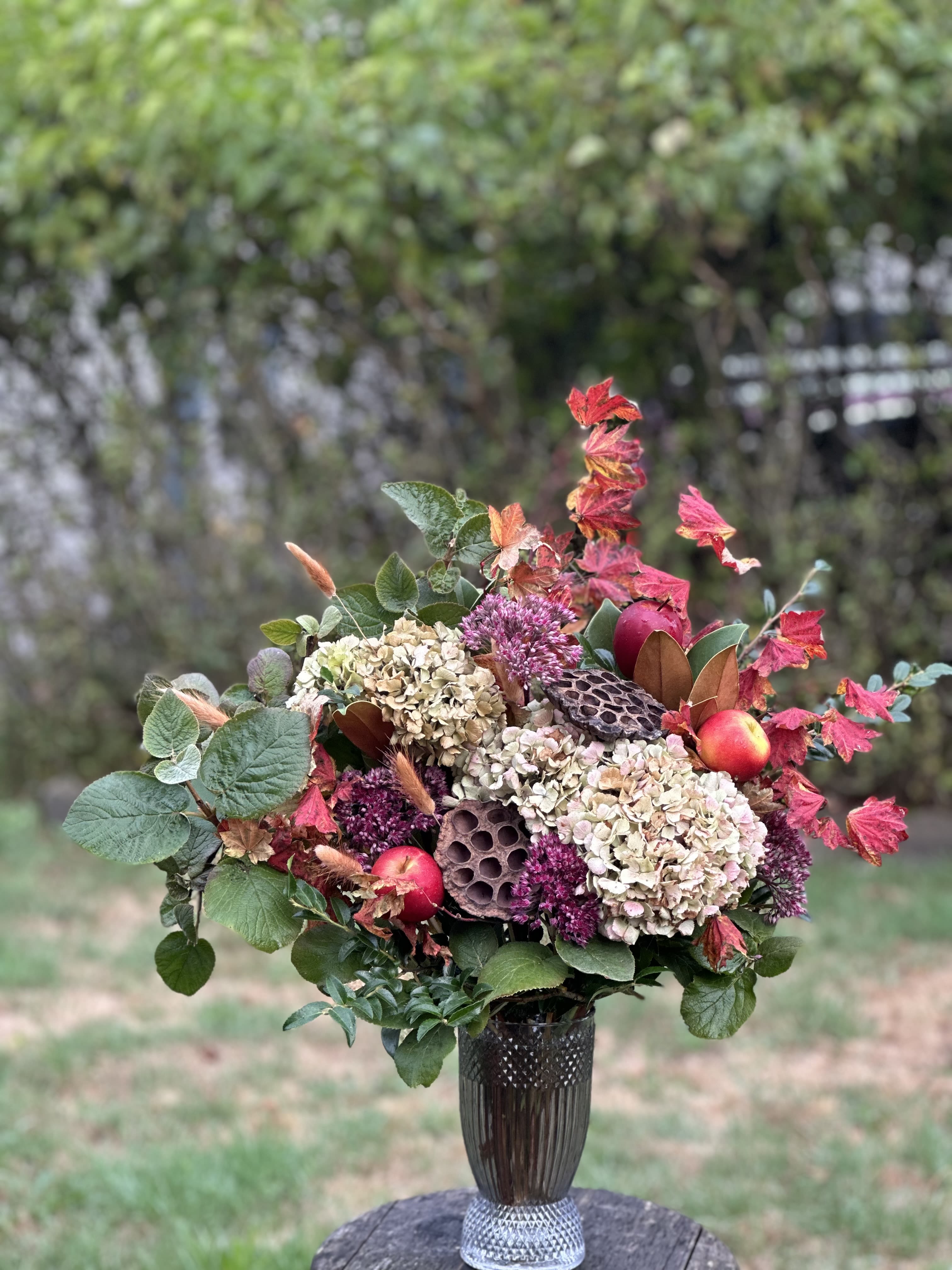 Autumn floral arrangement with hydrangeas and berries in a dark vase