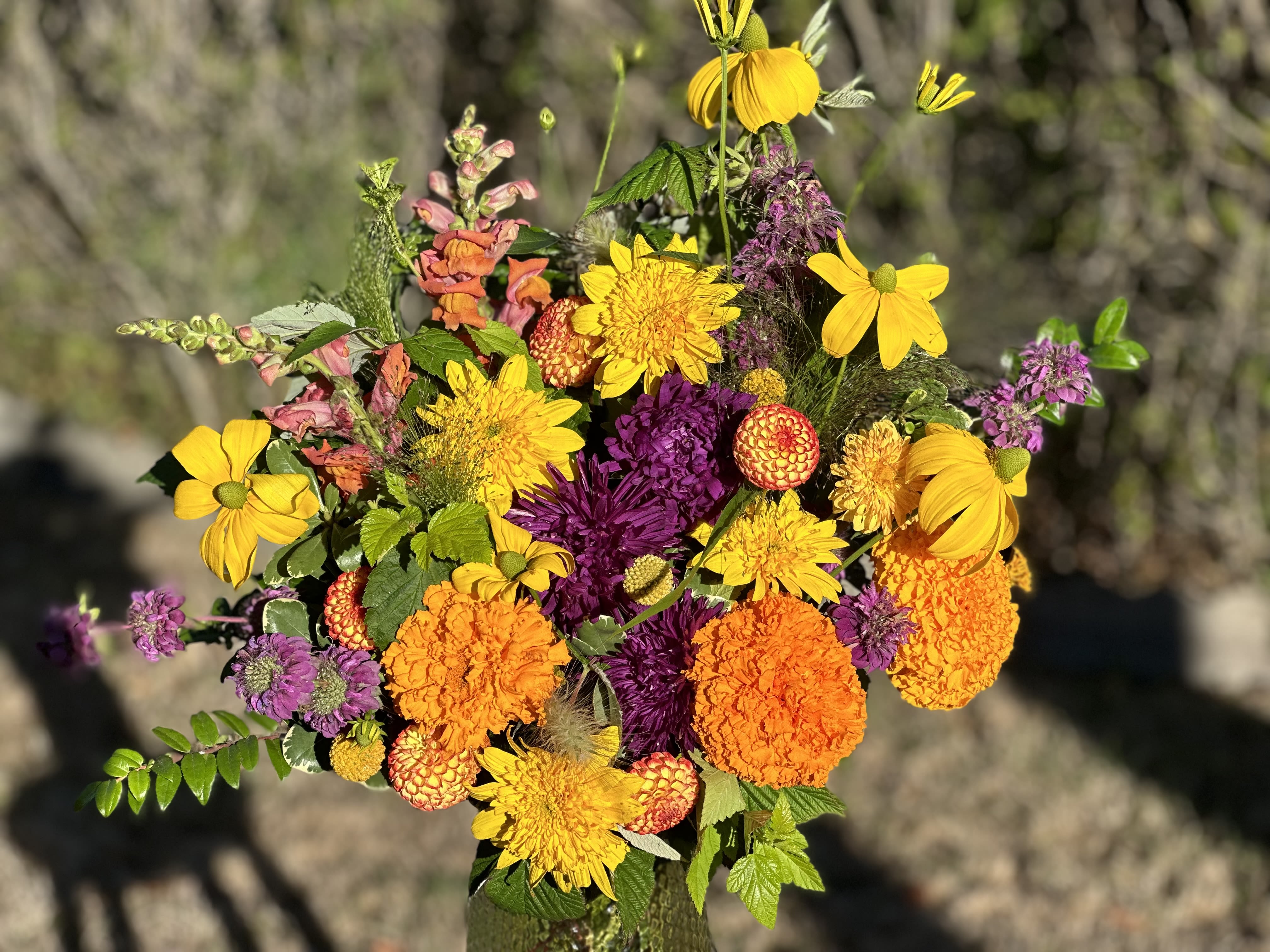 Bright bouquet of yellow, orange, and purple flowers in a vase