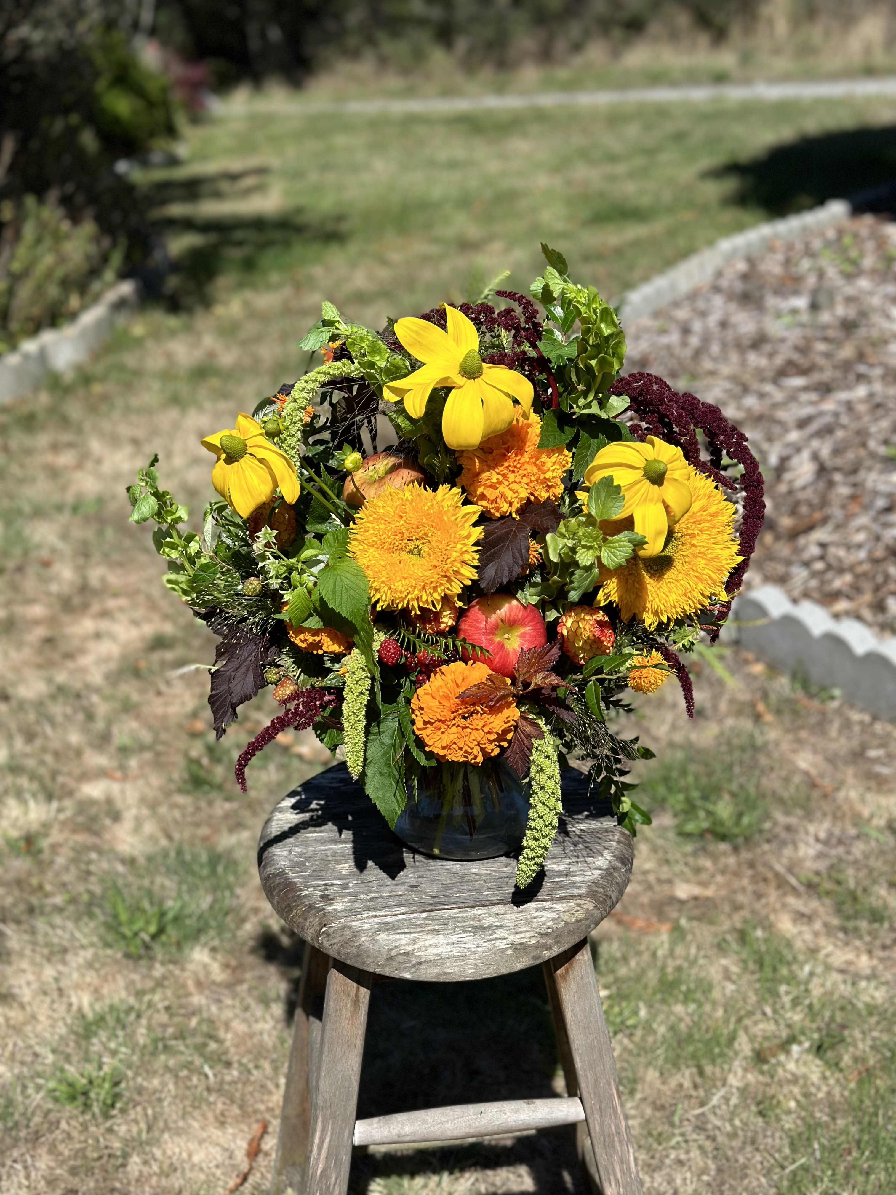 Bright mixed bouquet in a dark vase with yellow and orange blooms
