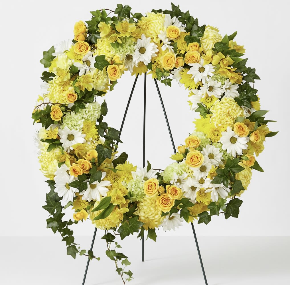 Yellow and white floral wreath on a black stand