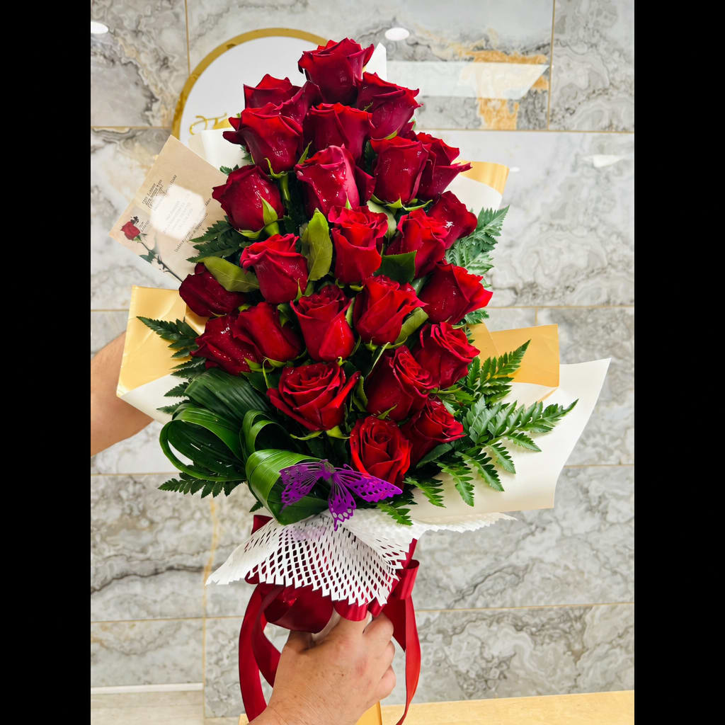 Bouquet of red roses wrapped in white and gold paper