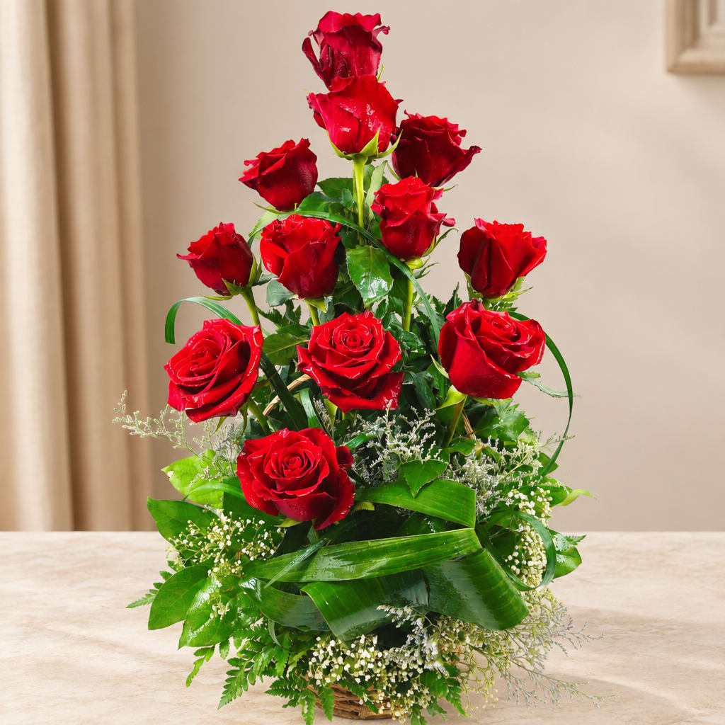 Red roses arranged in a basket with greenery
