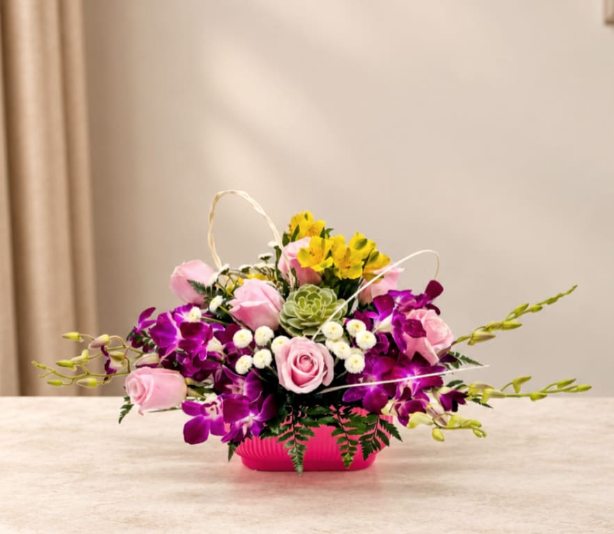 Pink roses and purple orchids arranged in a bright pink container
